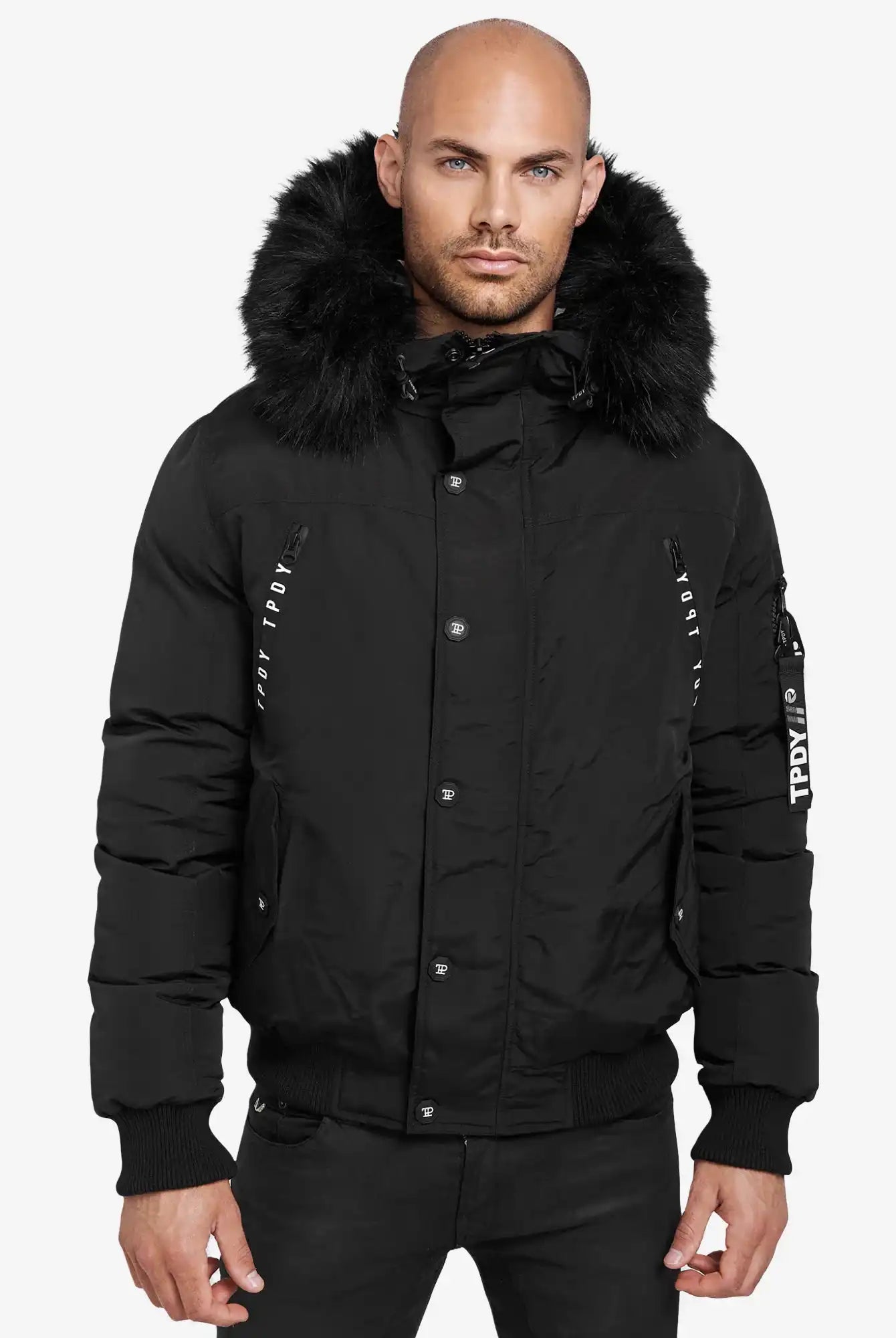 Ein Mann trägt den Trueprodigy Noah Winterparka mit Kapuze und Kunstfell mit Reißverschluss und Knöpfen sowie weißem Text auf dem linken Ärmel vor einem schlichten weißen Hintergrund.