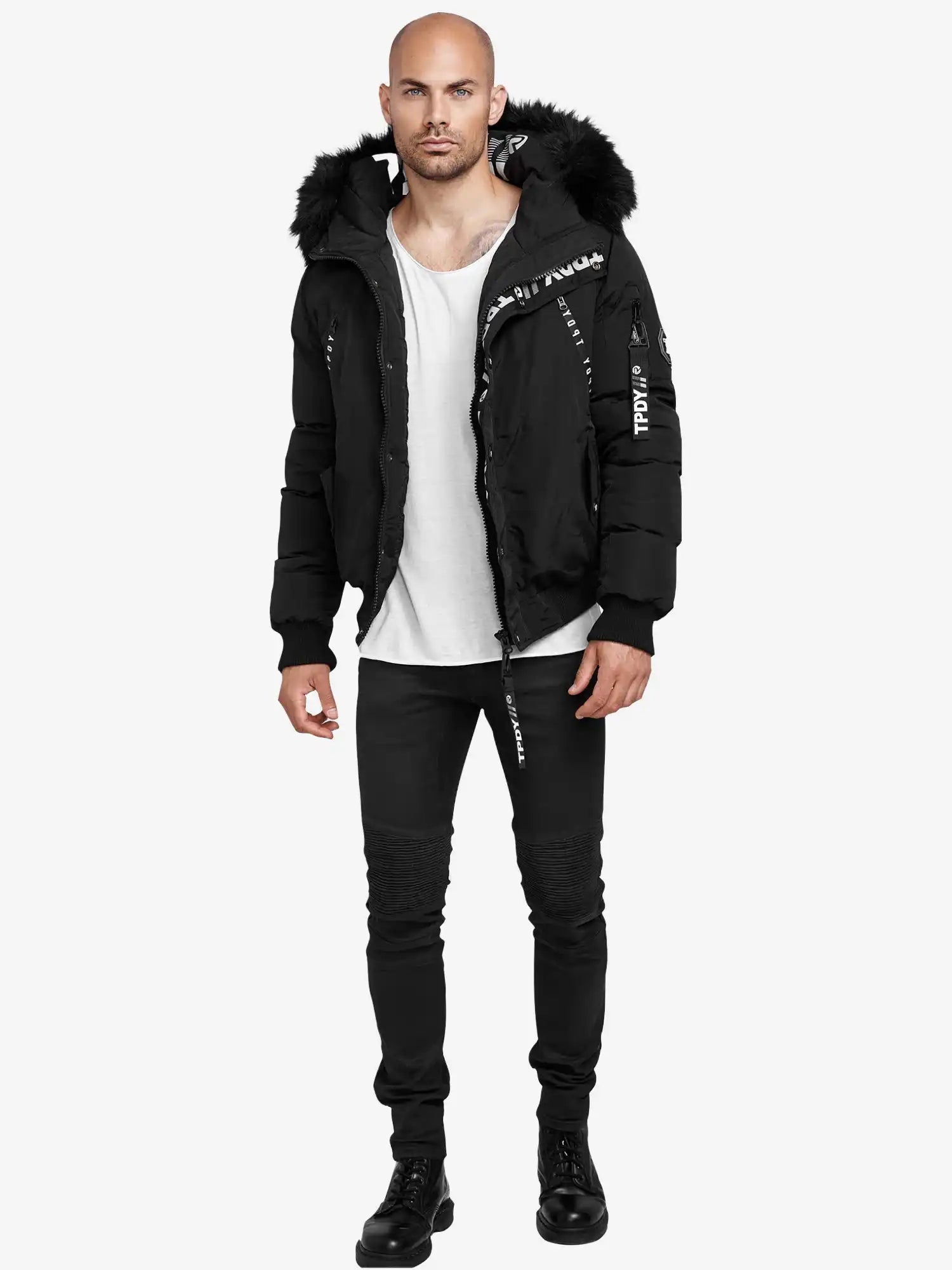 Ein Mann steht vor einem weißen Hintergrund und trägt die Trueprodigy Noah Winterparka mit Kapuze und Kunstfell, ein weißes T-Shirt, schwarze Jeans und schwarze Stiefel. Er blickt mit neutraler Miene nach vorne.