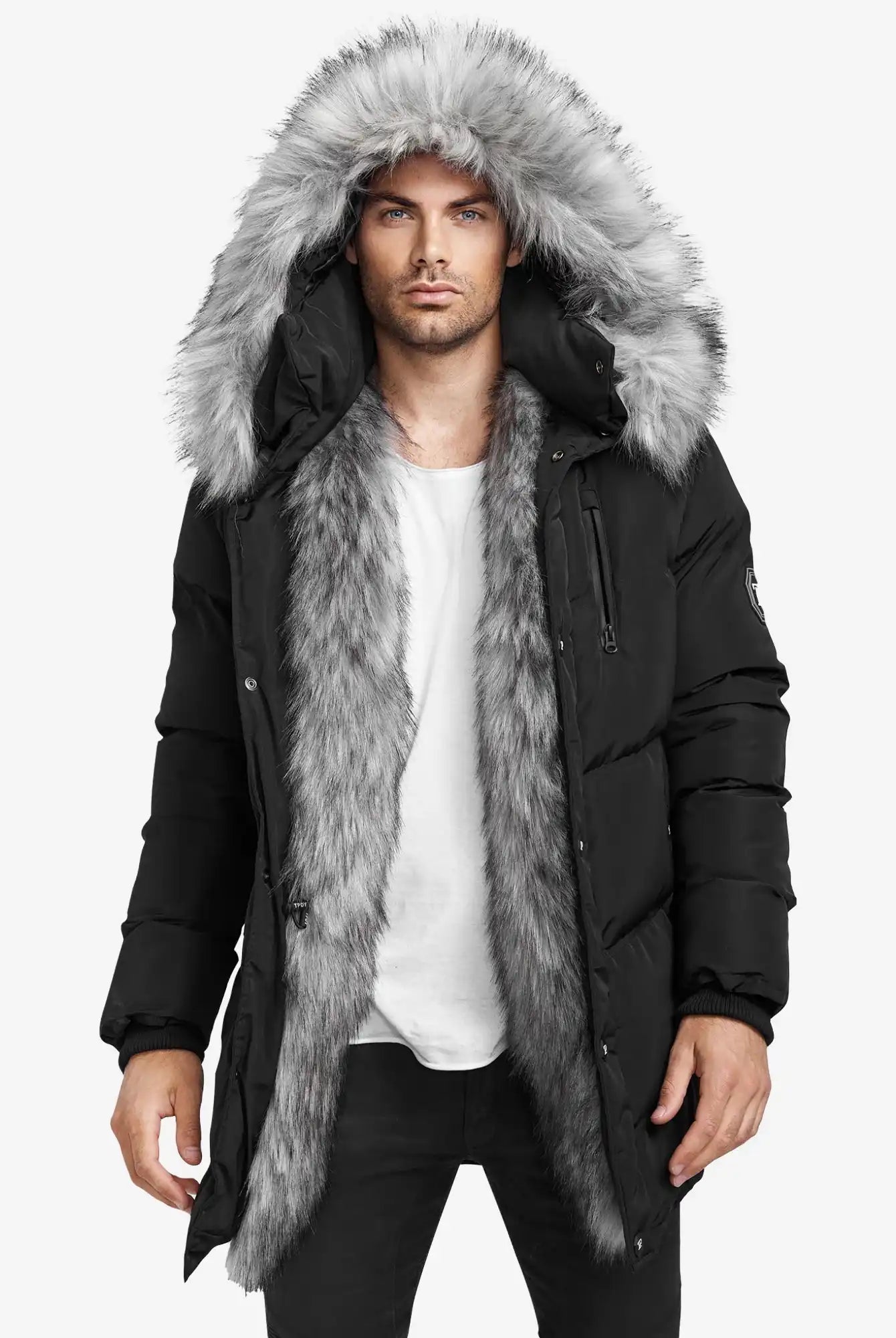 Ein Mann in einer Trueprodigy Zayn Winterjacke mit Kunstfell, die einen großen grauen Kunstfellbesatz an der Kapuze und am Innenfutter aufweist, steht vor einem schlichten weißen Hintergrund und trägt ein weißes T-Shirt und eine schwarze Hose.