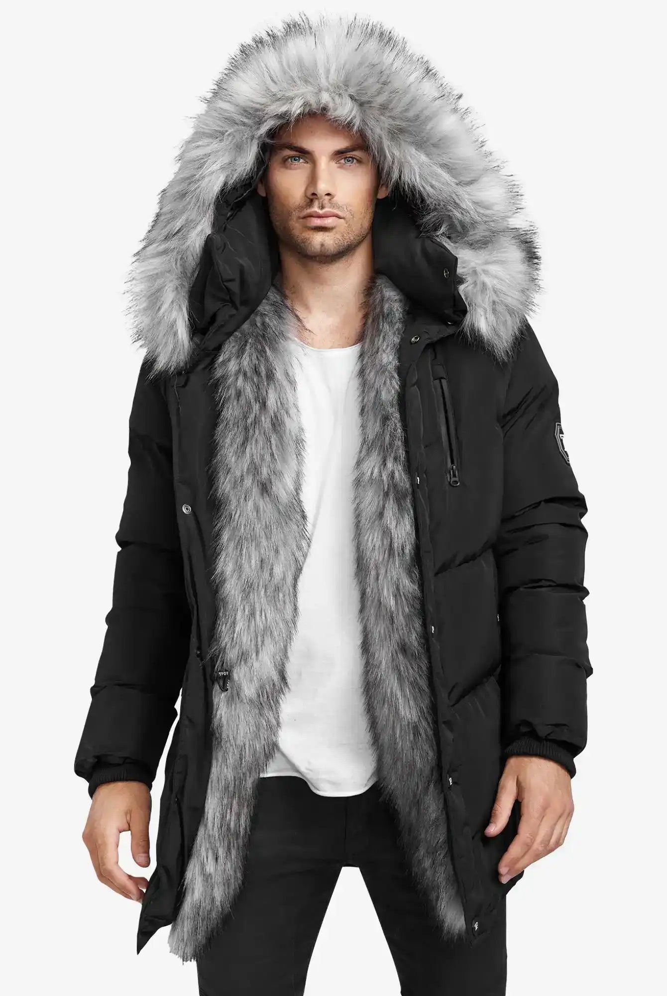 Ein Mann in einer Trueprodigy Zayn Winterjacke mit Kunstfell, die einen großen grauen Kunstfellbesatz an der Kapuze und am Innenfutter aufweist, steht vor einem schlichten weißen Hintergrund und trägt ein weißes T-Shirt und eine schwarze Hose.