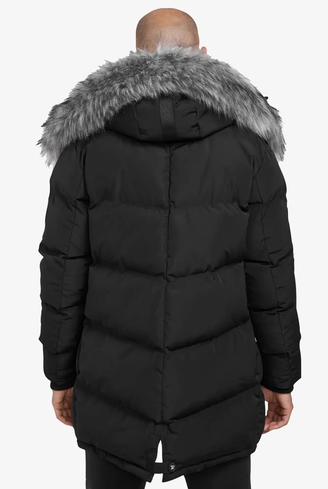 Eine Person, die die trueprodigy Zayn Winterjacke mit Kunstfell - einen langen, schwarzen, wasserabweisenden Herrenparka mit grauer Kunstfellkapuze - trägt, wird von hinten vor einem schlichten weißen Hintergrund gezeigt.