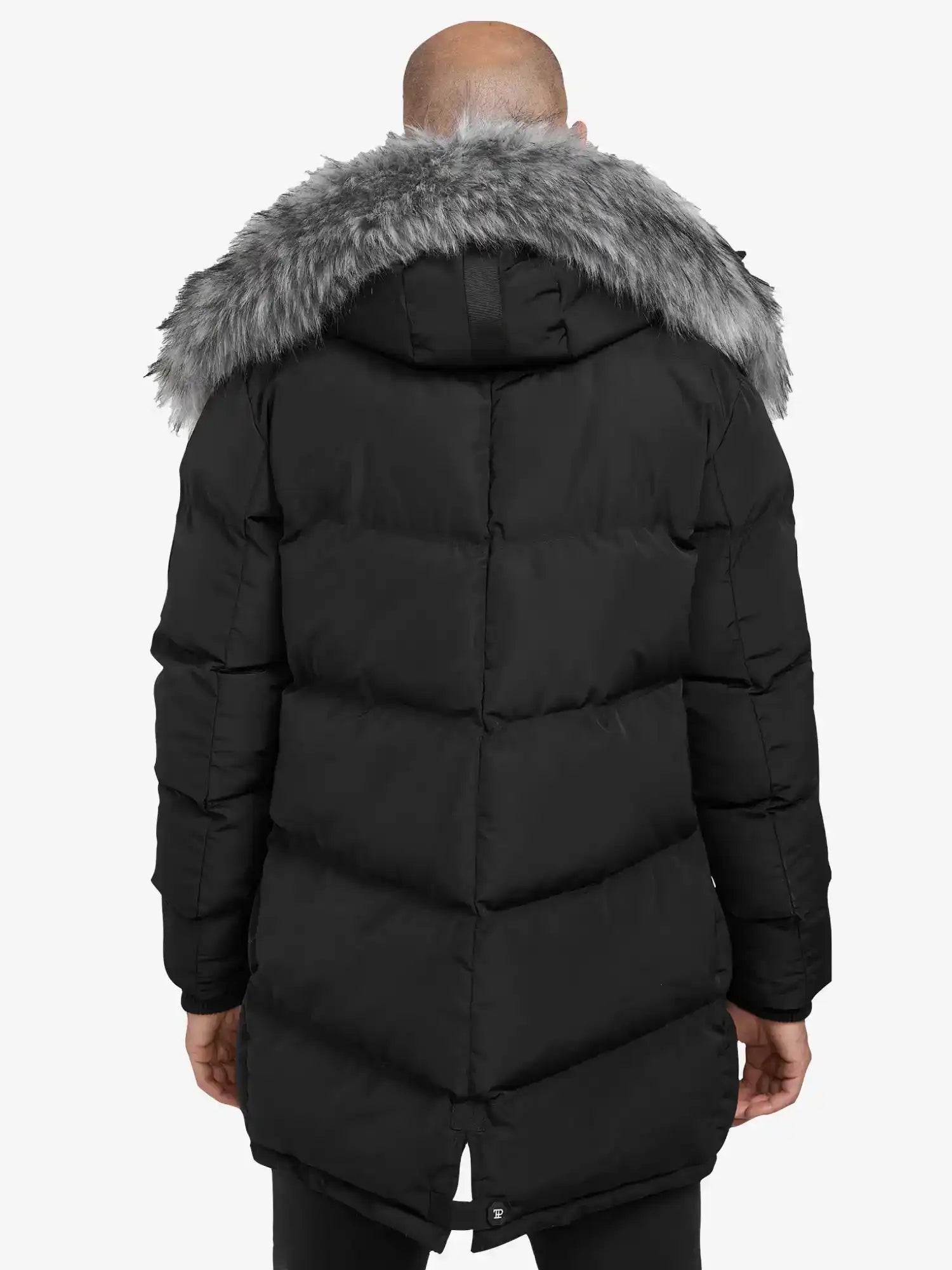 Eine Person, die die trueprodigy Zayn Winterjacke mit Kunstfell - einen langen, schwarzen, wasserabweisenden Herrenparka mit grauer Kunstfellkapuze - trägt, wird von hinten vor einem schlichten weißen Hintergrund gezeigt.