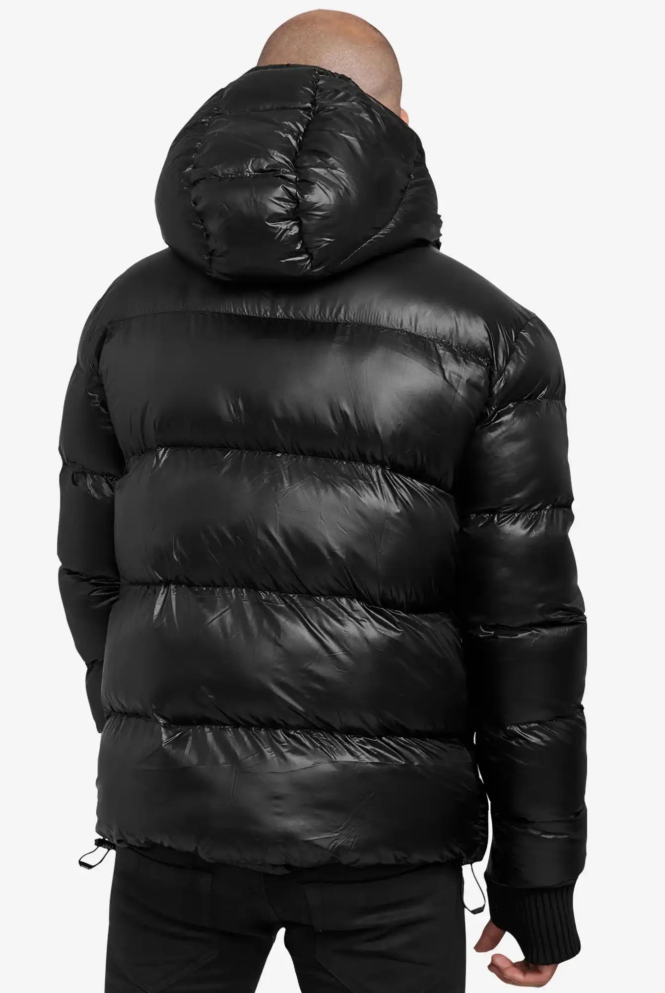 Abgebildet ist eine Person von hinten, die die trueprodigy Logan Pufferjacke mit Logo trägt. Die gesteppte Jacke mit Kapuze zeichnet sich durch horizontale Nähte aus und hebt sich von einem schlichten weißen Hintergrund ab.