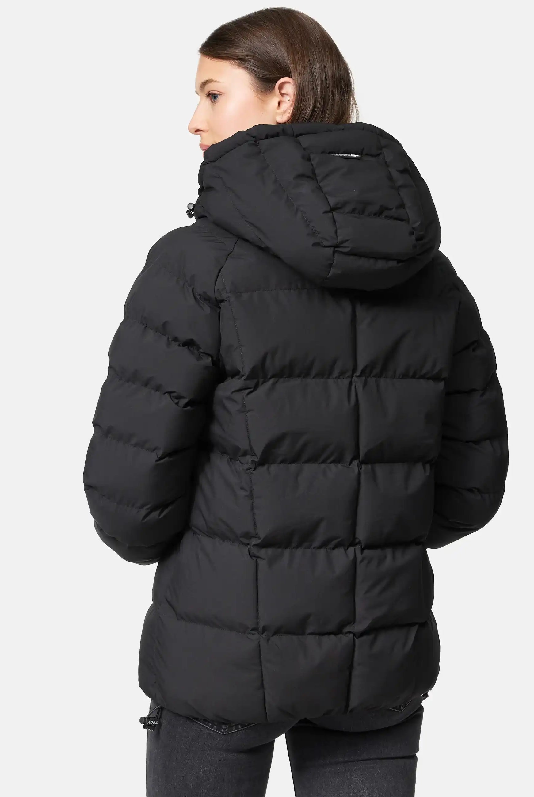 Eine Person mit glattem braunen Haar trägt die schwarze Murphy F Matte Steppjacke mit Kapuze von trueprodigy. Die wasserabweisende Jacke wird auf einem schlichten weißen Hintergrund von hinten gezeigt.