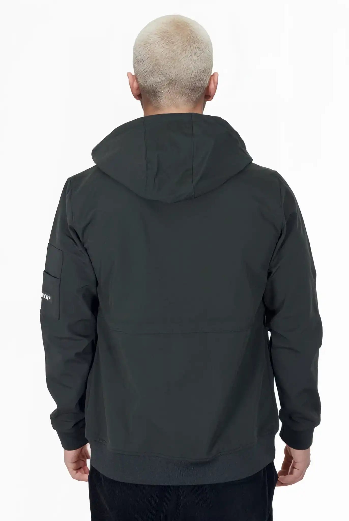 Eine Person mit kurzen, gebleichten blonden Haaren ist von hinten zu sehen, die die Trueprodigy Lucas Leichte Herrenjacke mit Brust- und Ärmelbadge trägt und vor einem schlichten weißen Hintergrund steht.