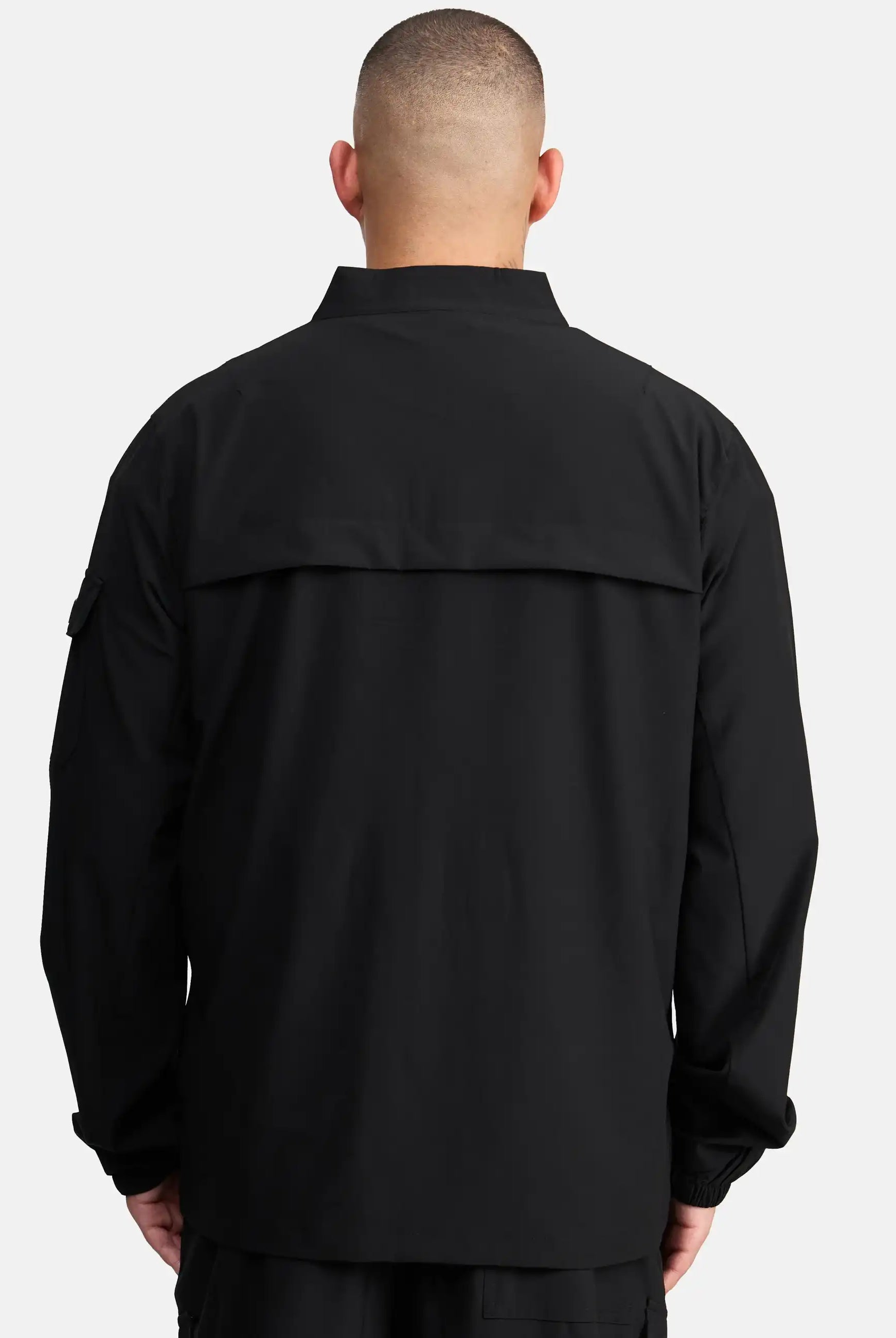 Eine Person mit kurz geschnittenem Haar ist von hinten zu sehen, die die trueprodigy Henry Leichte Sportjacke mit Stehkragen trägt, eine locker geschnittene Herrenjacke mit Kragen und Klappe vor einem schlichten, hellen Hintergrund.