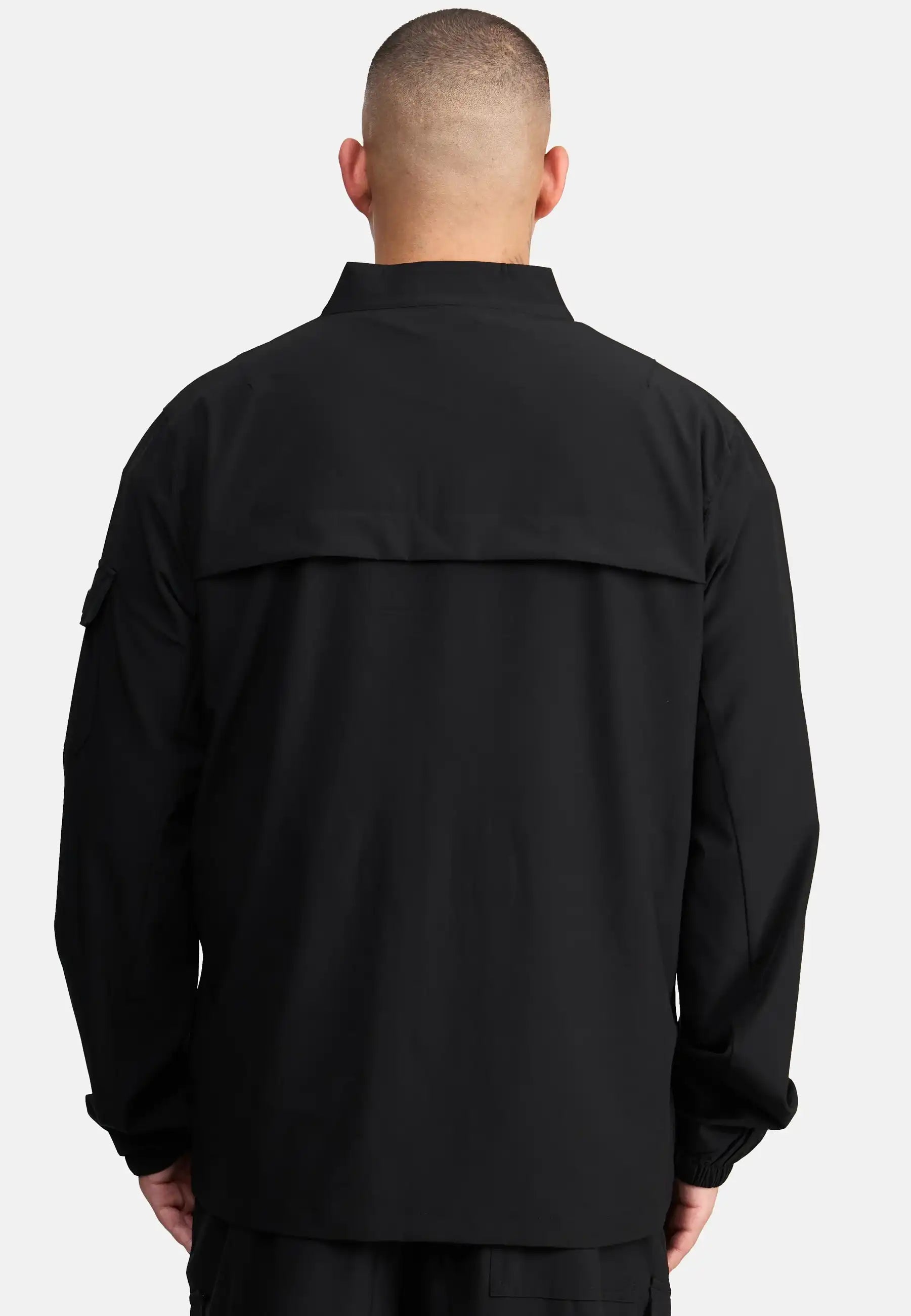 Eine Person mit kurz geschnittenem Haar ist von hinten zu sehen, die die trueprodigy Henry Leichte Sportjacke mit Stehkragen trägt, eine locker geschnittene Herrenjacke mit Kragen und Klappe vor einem schlichten, hellen Hintergrund.