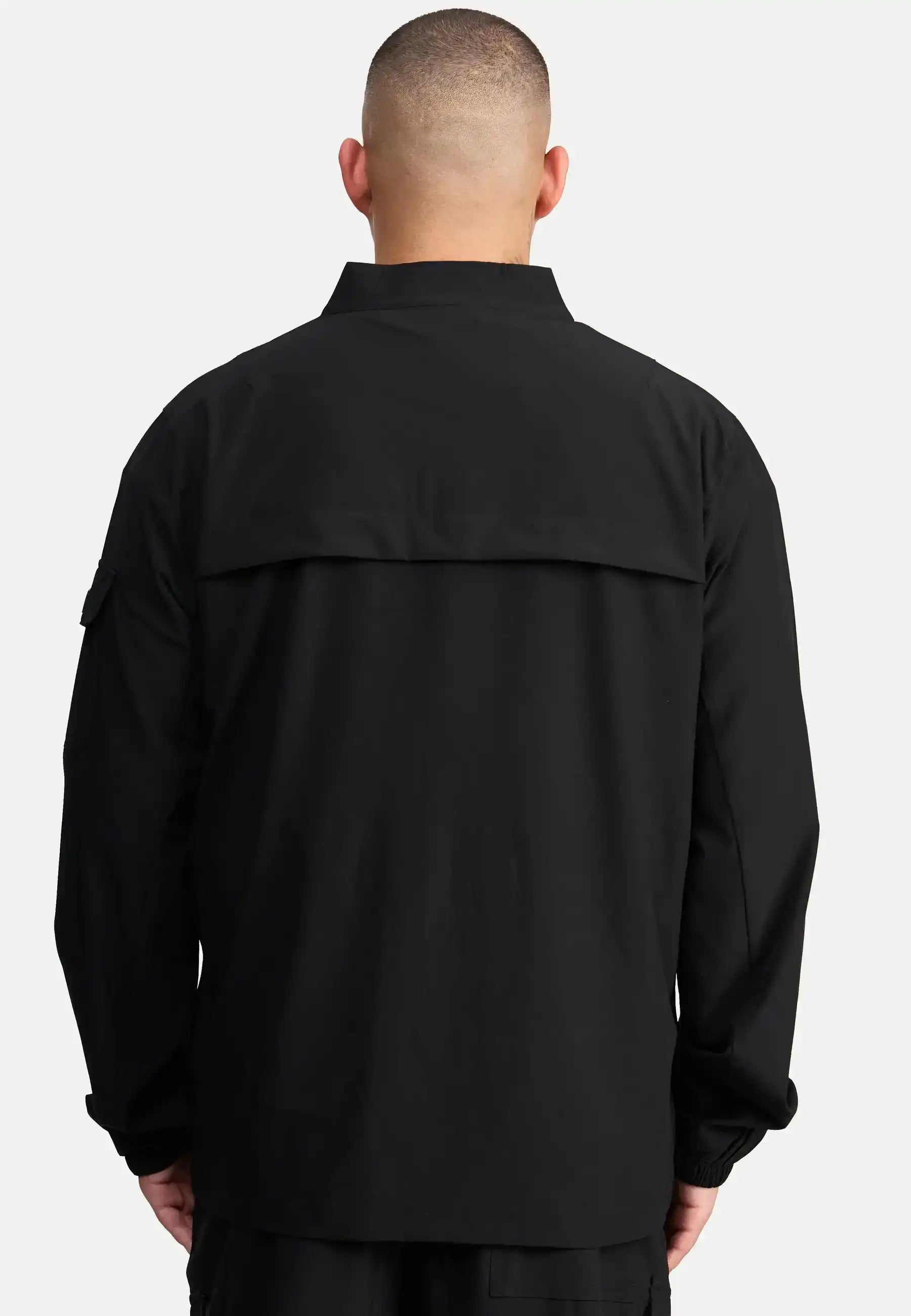 Eine Person mit kurz geschnittenem Haar ist von hinten zu sehen, die die trueprodigy Henry Leichte Sportjacke mit Stehkragen trägt, eine locker geschnittene Herrenjacke mit Kragen und Klappe vor einem schlichten, hellen Hintergrund.
