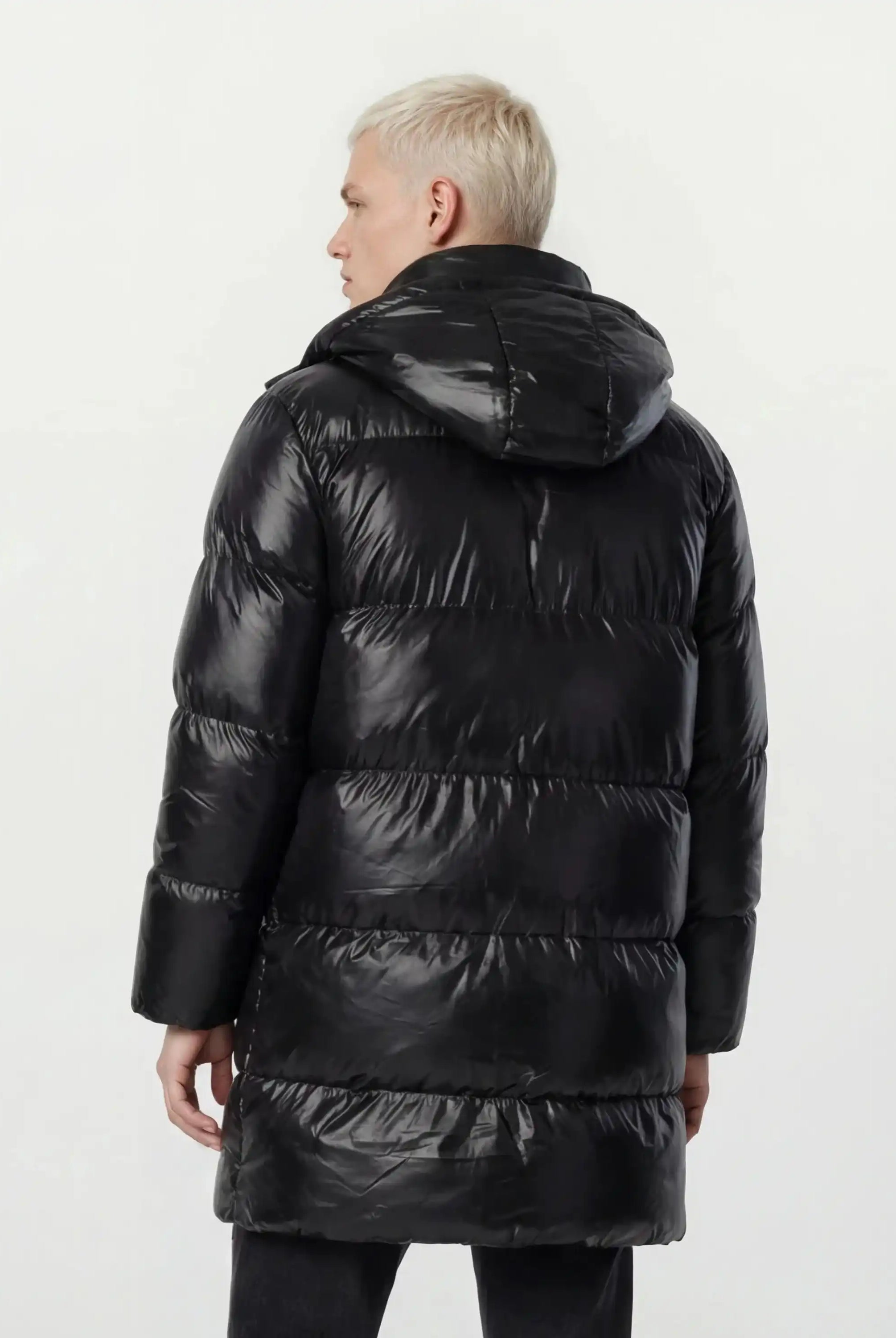 Eine Person mit kurzen blonden Haaren trägt eine trueprodigy Herren Winterjacke mit hochglänzender Oberfläche im Regular Fit, von der Kamera abgewandt vor einem schlichten weißen Hintergrund.
