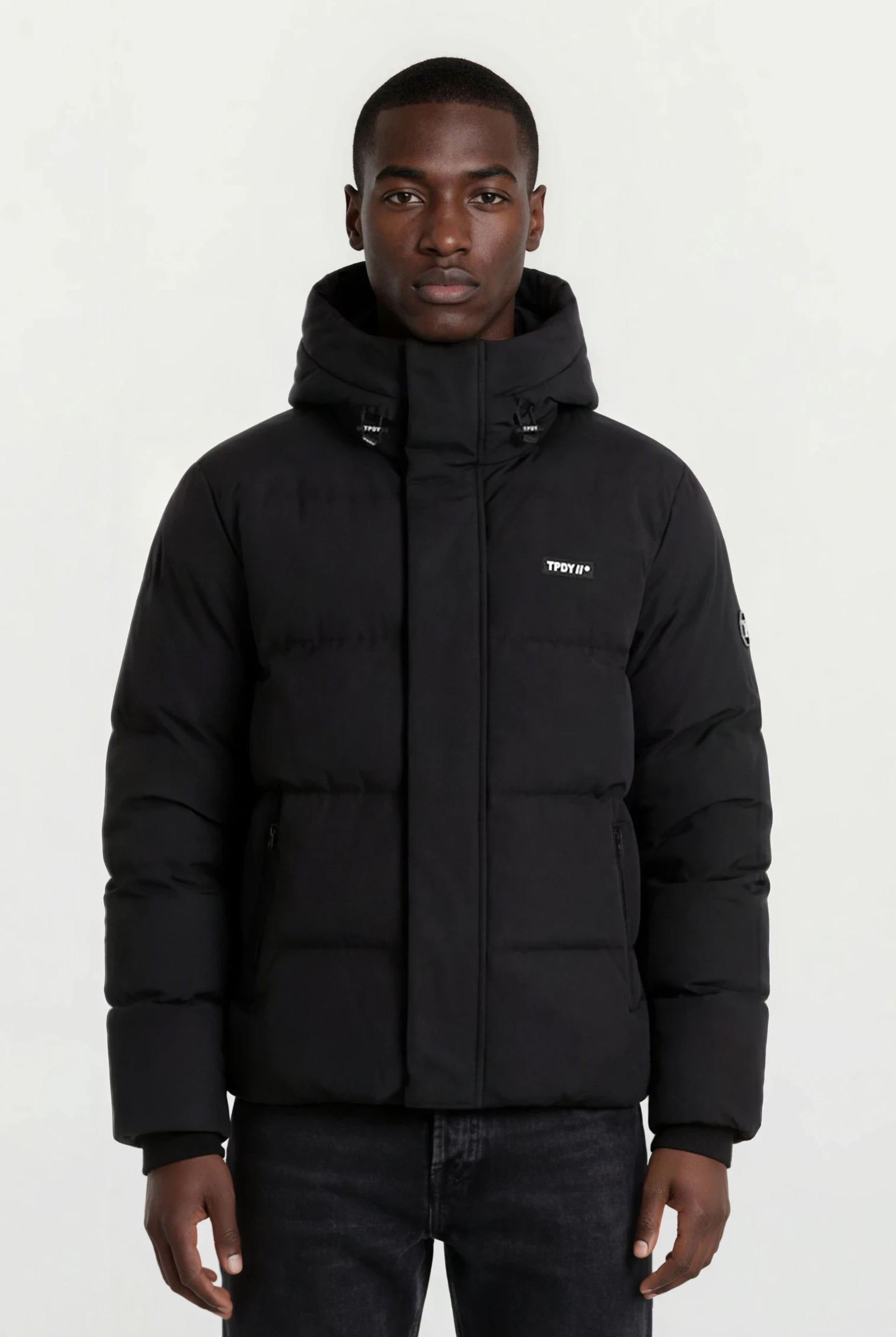 Ein Mann trägt eine trueprodigy Herren Winterjacke mit fester Kapuze im Oversized Fit.