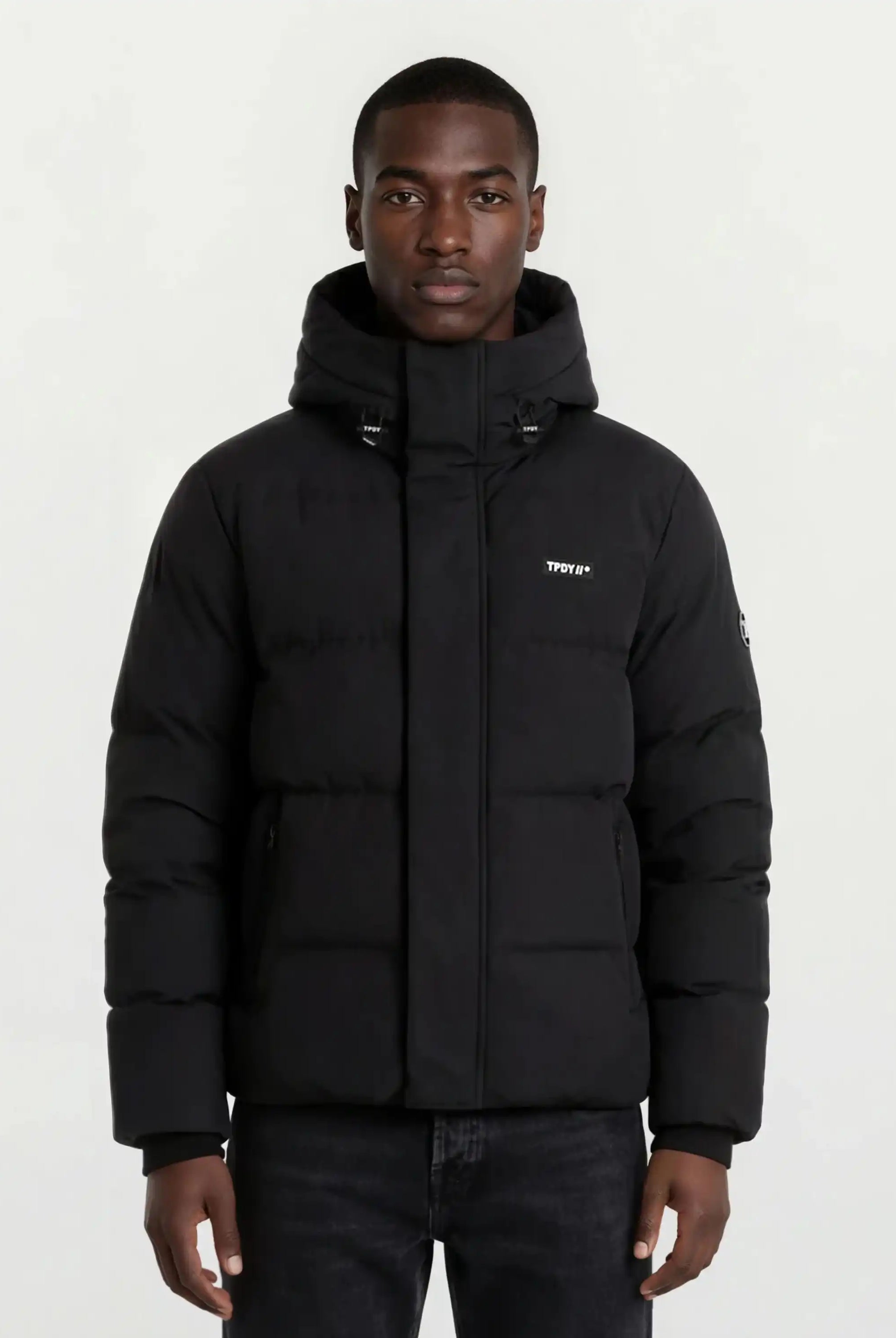Ein Mann trägt eine trueprodigy Herren Winterjacke mit fester Kapuze im Oversized Fit.