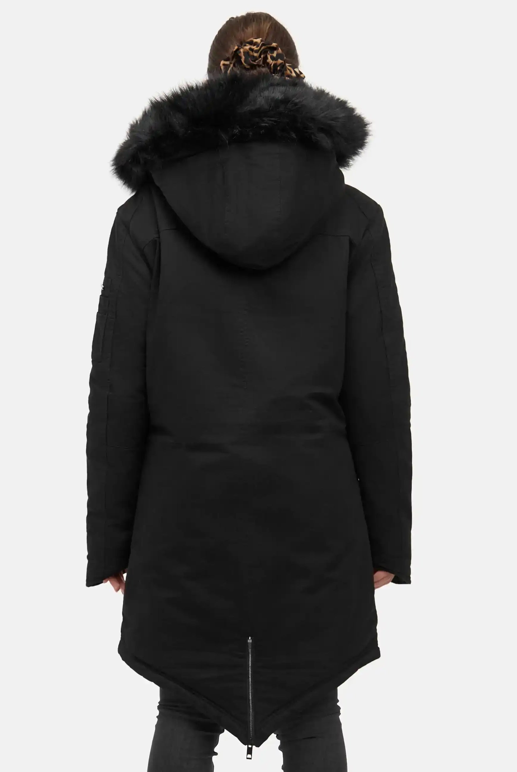 Eine Frau mit geflochtenem Haar ist von hinten zu sehen, die den trueprodigy Harvey F Damenparka mit Kapuze und Kunstfell mit spitzem Saum vor einem schlichten hellen Hintergrund trägt.