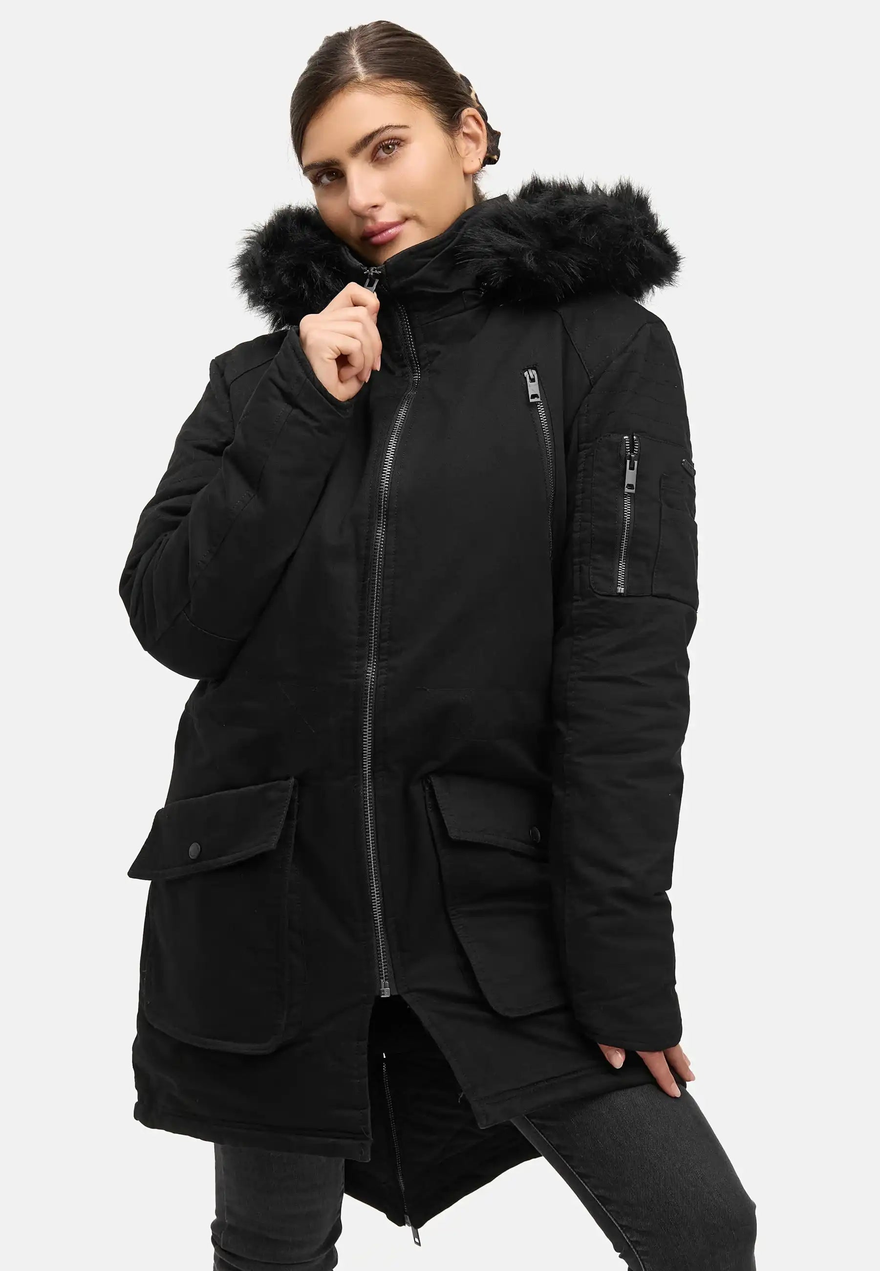 Eine Person trägt den trueprodigy Harvey F Damenparka mit Kapuze und Kunstfell, mit mehreren Reißverschluss- und Pattentaschen und einem Reißverschluss auf der Vorderseite, vor einem schlichten, hellen Hintergrund.