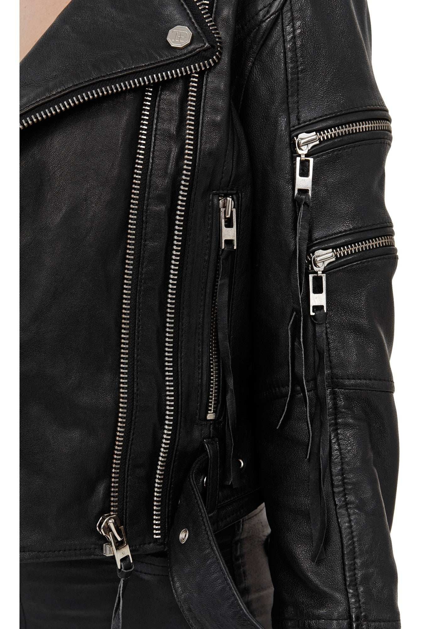 Nahaufnahme der trueprodigy Izzy Bikerlederjacke mit Gürtel, die mit mehreren silbernen Reißverschlüssen, Druckknöpfen und einem Taillengürtel ausgestattet ist. Die detaillierte Hardware und das strukturierte Schafsleder sind deutlich sichtbar.