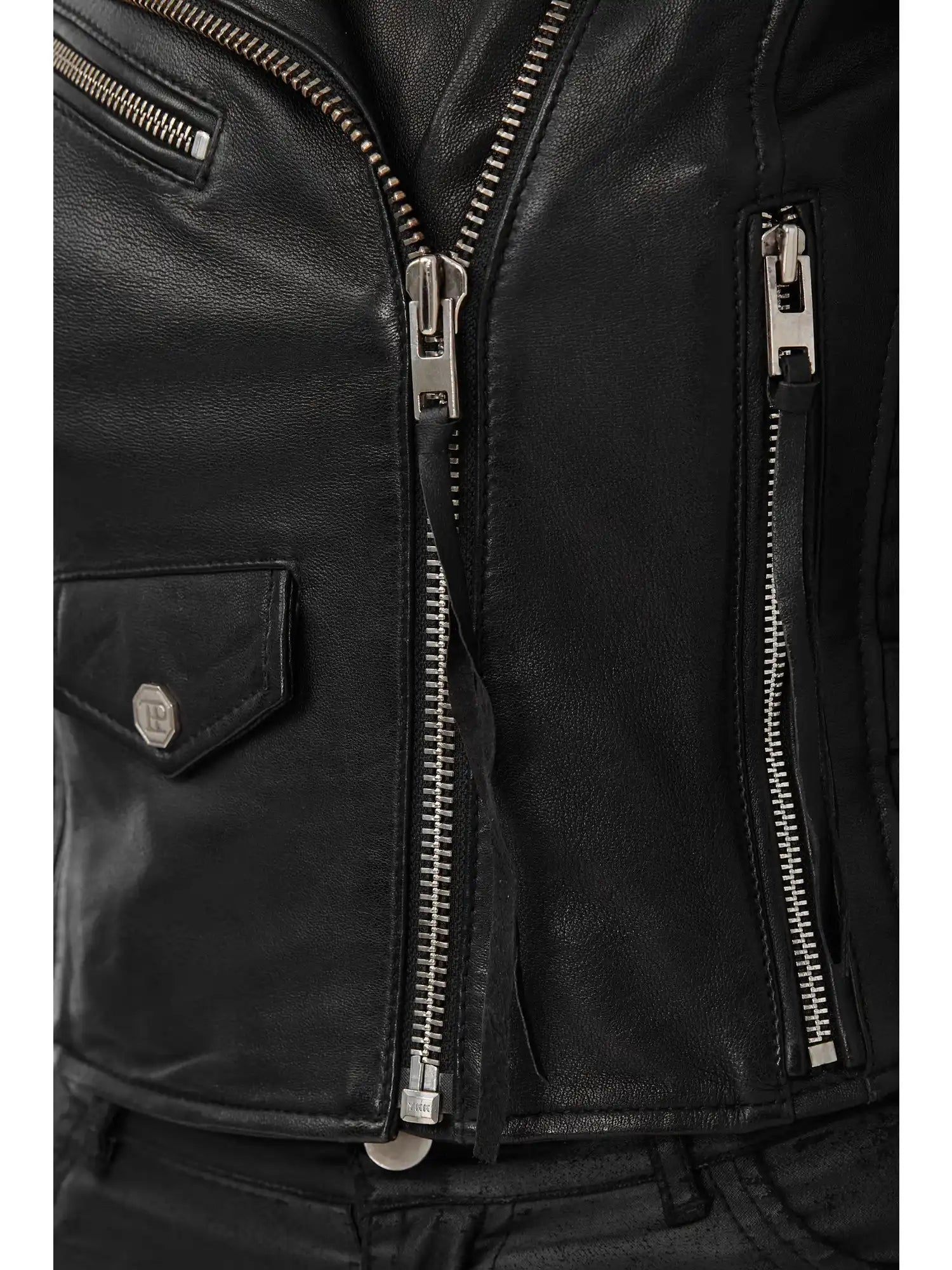 Nahaufnahme der trueprodigy Freya Bikerlederjacke mit Schnallen in schwarzem Schafsleder mit silbernen Reißverschlüssen und kleiner Klappentasche, detailreiche Nähte und Textur. Der klassische Biker-Look passt ideal zu schwarzen Hosen.