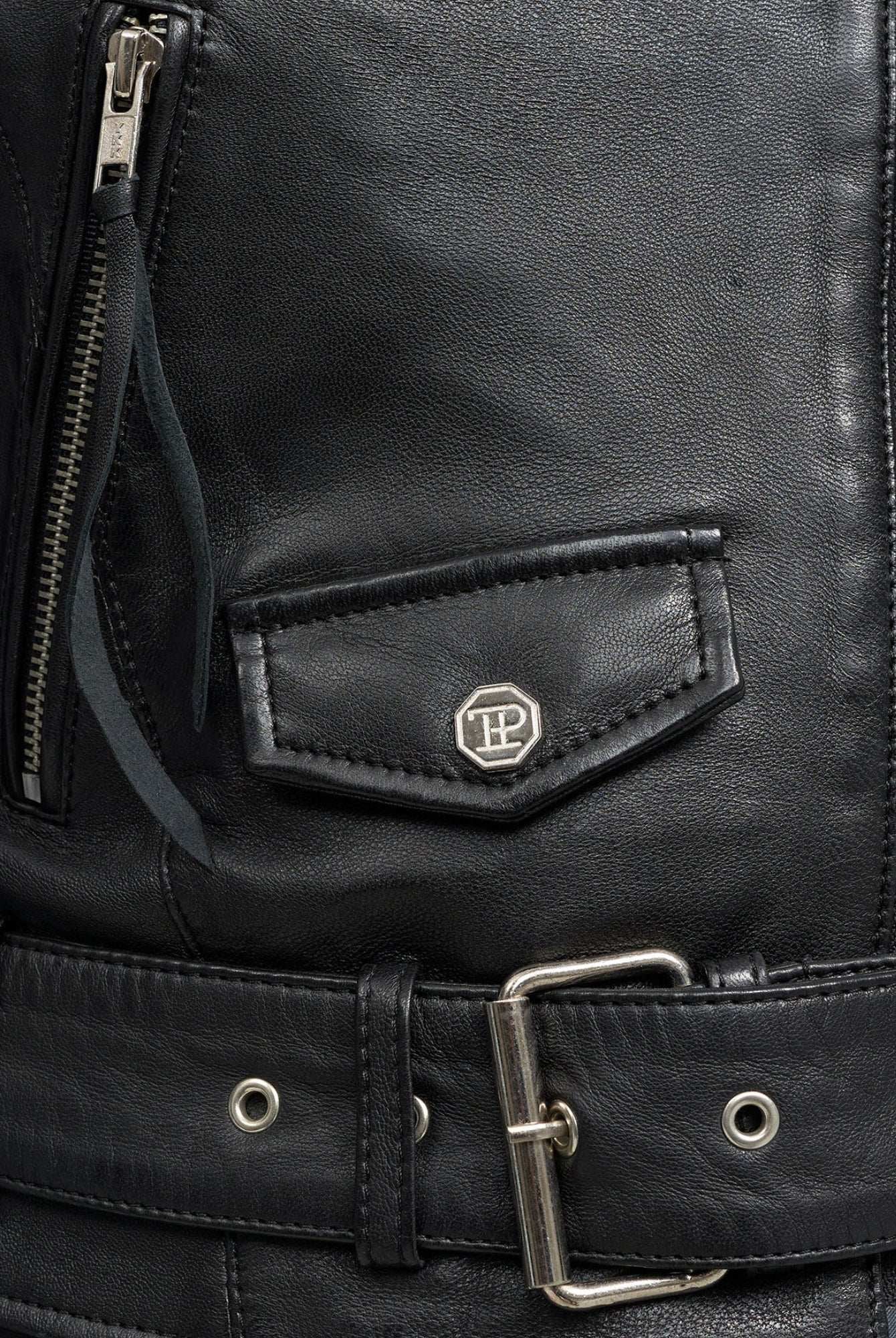 Nahaufnahme der trueprodigy Laila Lederjacke mit Druck, die mit einer Reißverschlusstasche, einer kleinen Pattentasche mit silbernem Emblem und einem passenden Ledergürtel ausgestattet ist - ideal für einen ausgefallenen Trend-Look.