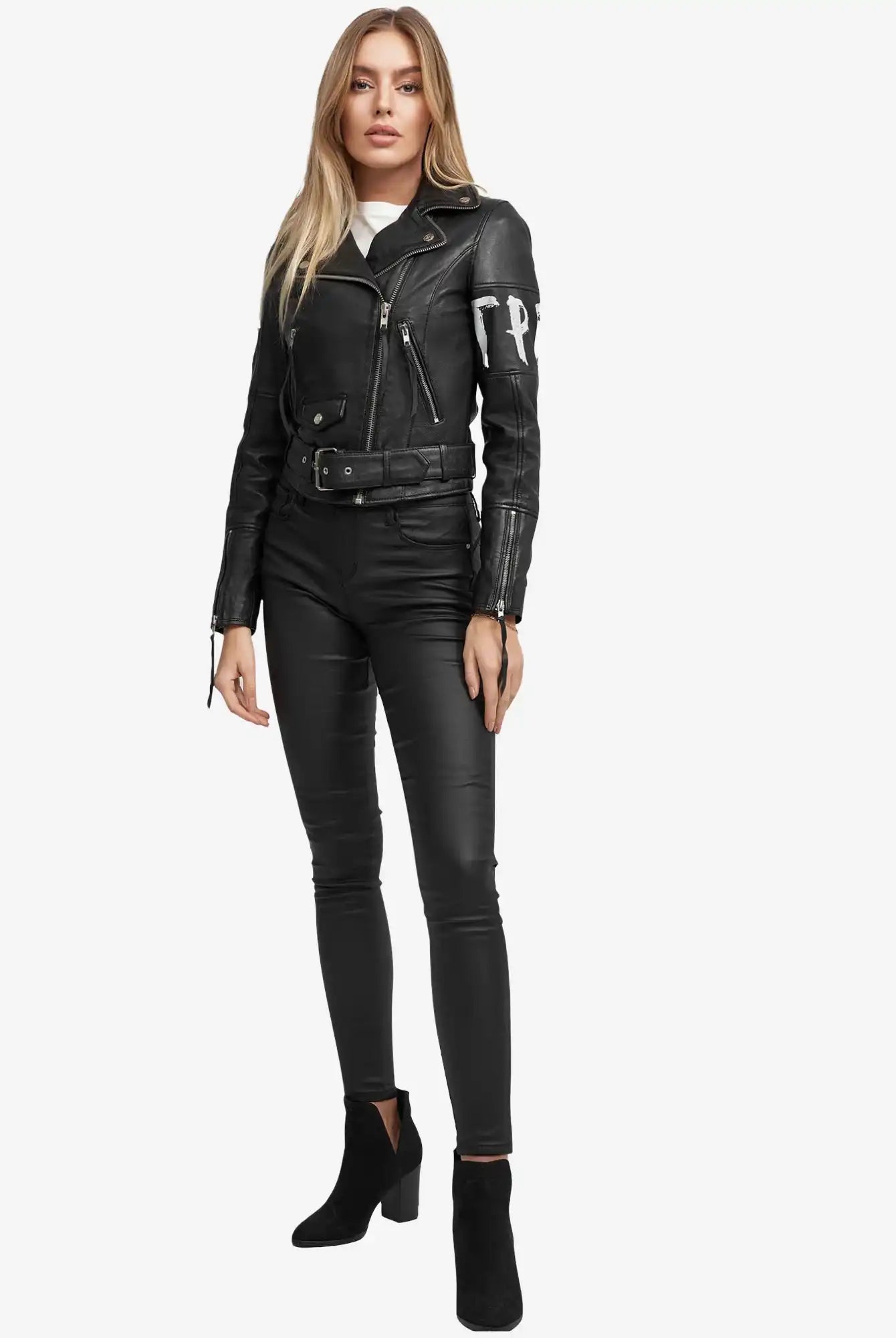 Eine Frau mit langen blonden Haaren steht vor einem weißen Hintergrund und trägt die trueprodigy Laila Lederjacke mit Druck, gepaart mit einer schwarzen, taillierten Hose und Ankle Boots, und präsentiert einen zeitlosen Trend-Look.