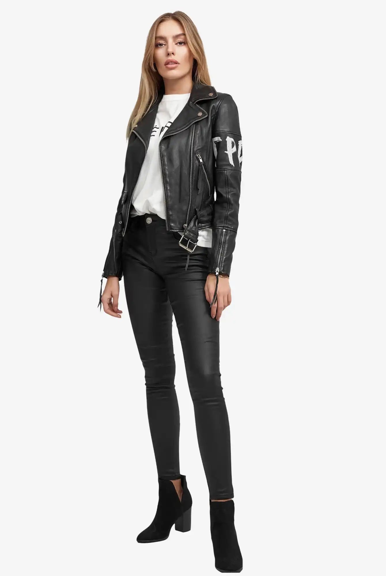 Eine Person trägt die Laila Lederjacke mit Druck von trueprodigy über einem weißen T-Shirt, dazu schwarze Skinny Pants und schwarze heeled Ankle Boots. Sie hat lange, glatte Haare und einen neutralen Gesichtsausdruck.