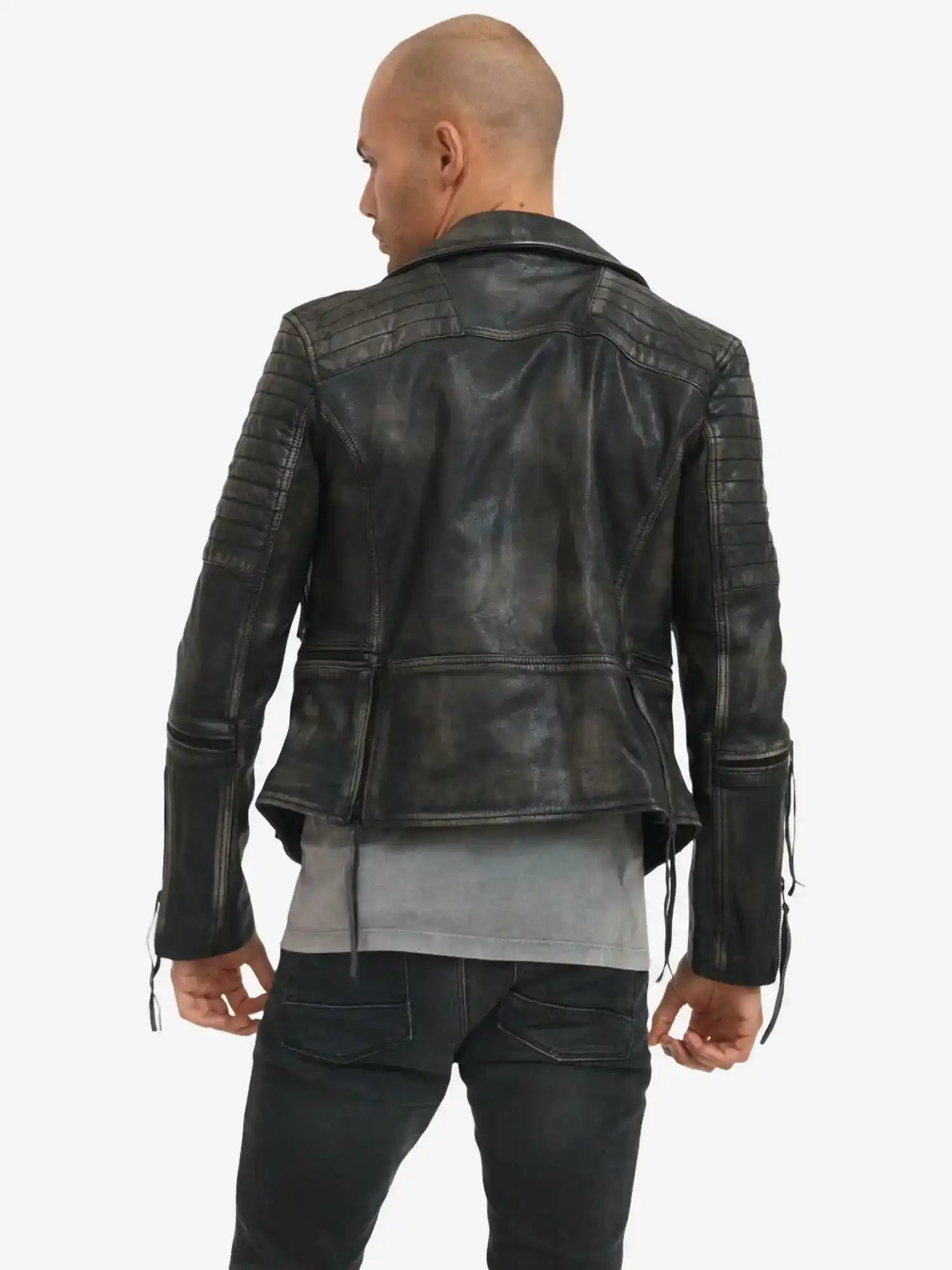 Eine Person mit rasiertem Kopf steht rückwärts zur Kamera und trägt eine schwarze "Bryan Lederjacke mit Vintage Optik" von trueprodigy im Biker-Stil mit gesteppten Details, kombiniert mit dunklen Jeans.