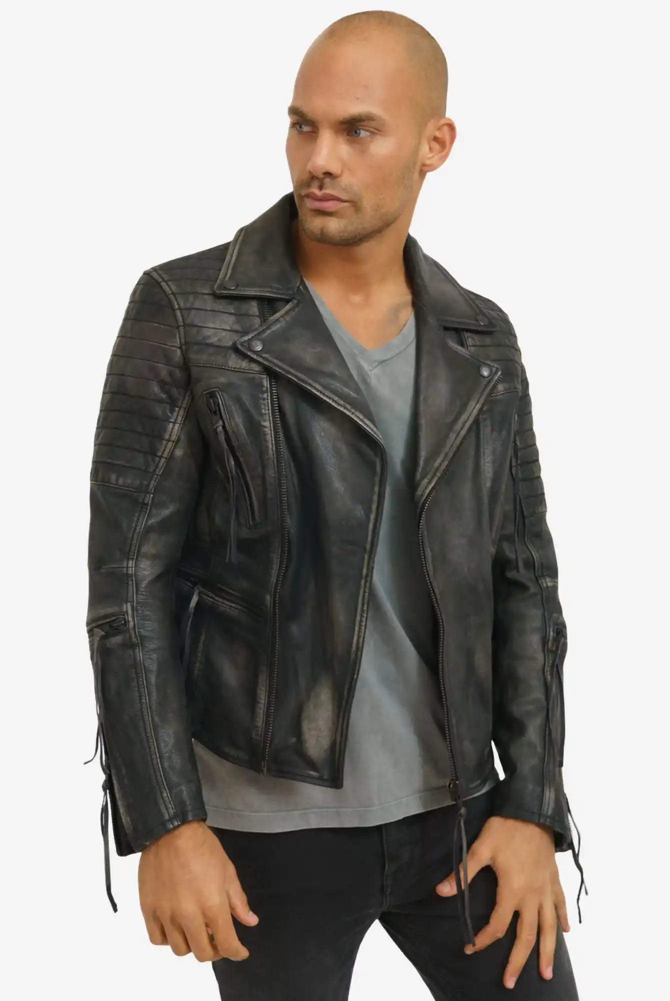 Ein Mann mit rasiertem Kopf modelliert die trueprodigy Bryan Lederjacke mit Vintage Optik über einem grauen T-Shirt und einer schwarzen Hose vor einem schlichten weißen Hintergrund.