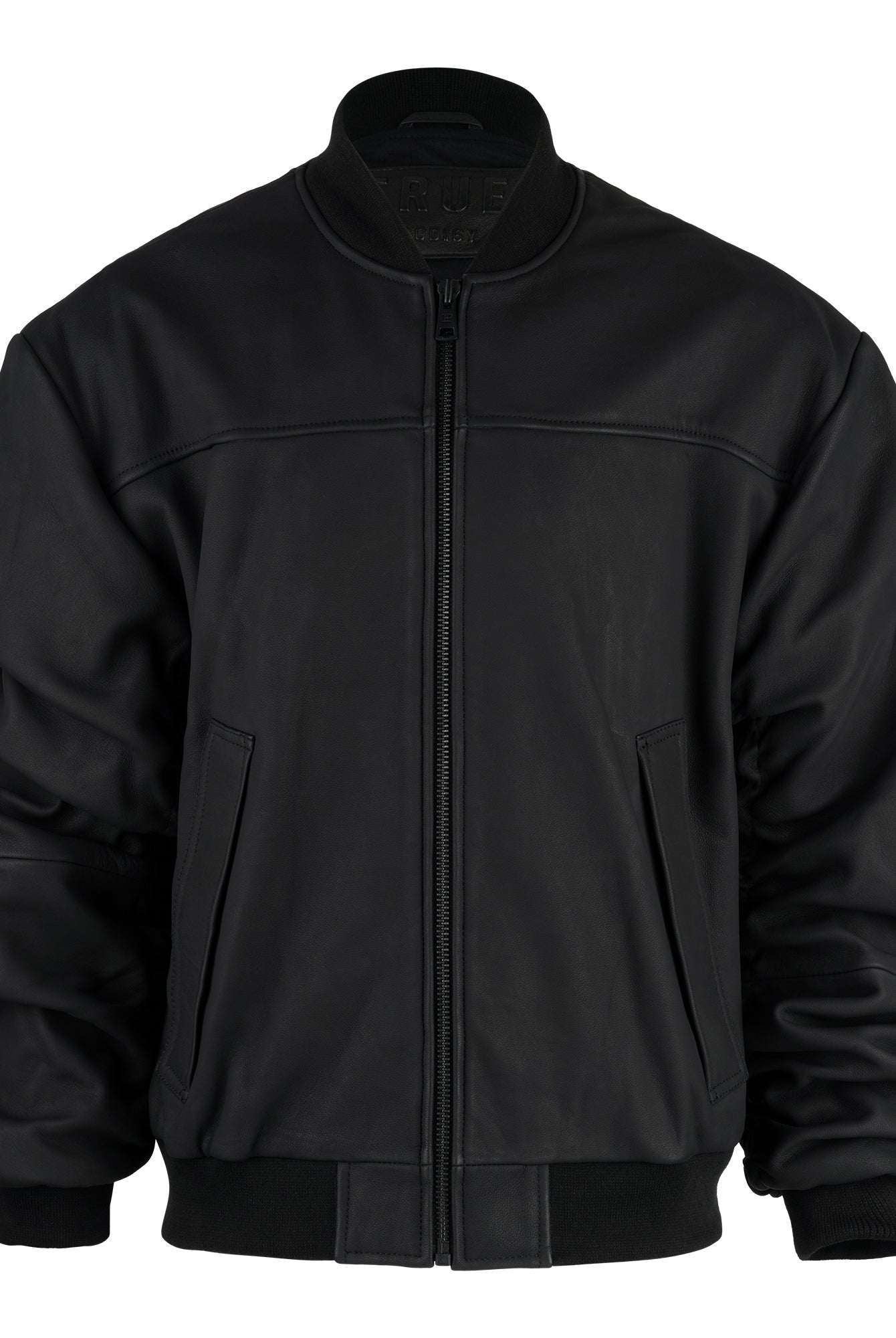 Die trueprodigy Bomber Lederjacke Herren "Nazar" im Oversize-Schnitt aus schwarzem Schafsleder zeigt sich mit Frontreißverschluss, zwei Seitentaschen sowie gerippten Bündchen, Kragen und Saum vor weißem Hintergrund.