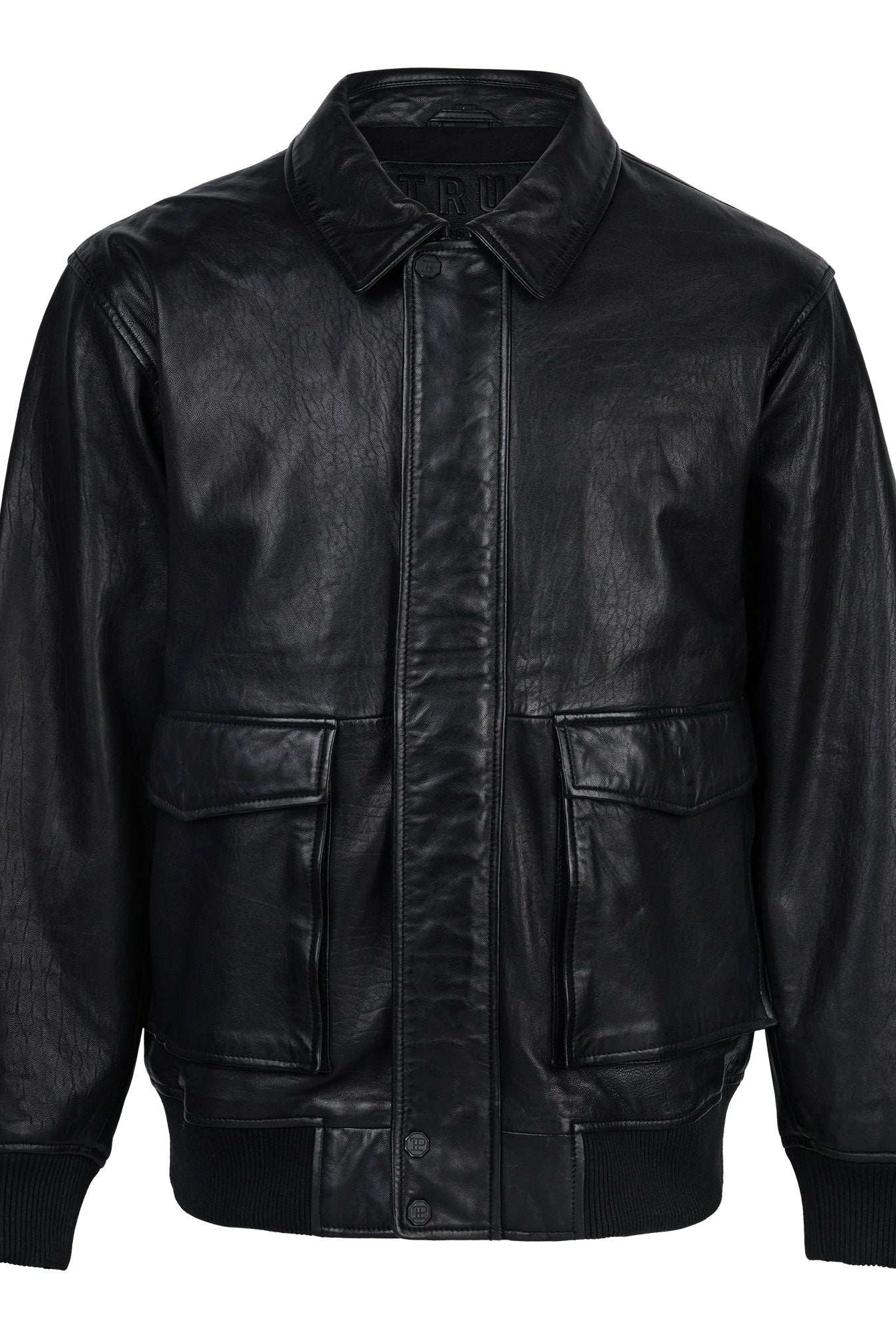 Die Ryder Oversize-Lederjacke von trueprodigy, gefertigt aus hochwertigem Schafsleder, verfügt über einen Stehkragen, 3D-Silikonlogo, Retro-Details, Frontreißverschluss und Druckknopfverschluss, zwei große Pattentaschen sowie gerippte Bündchen und Saum. Dargestellt auf weißem Hintergrund.