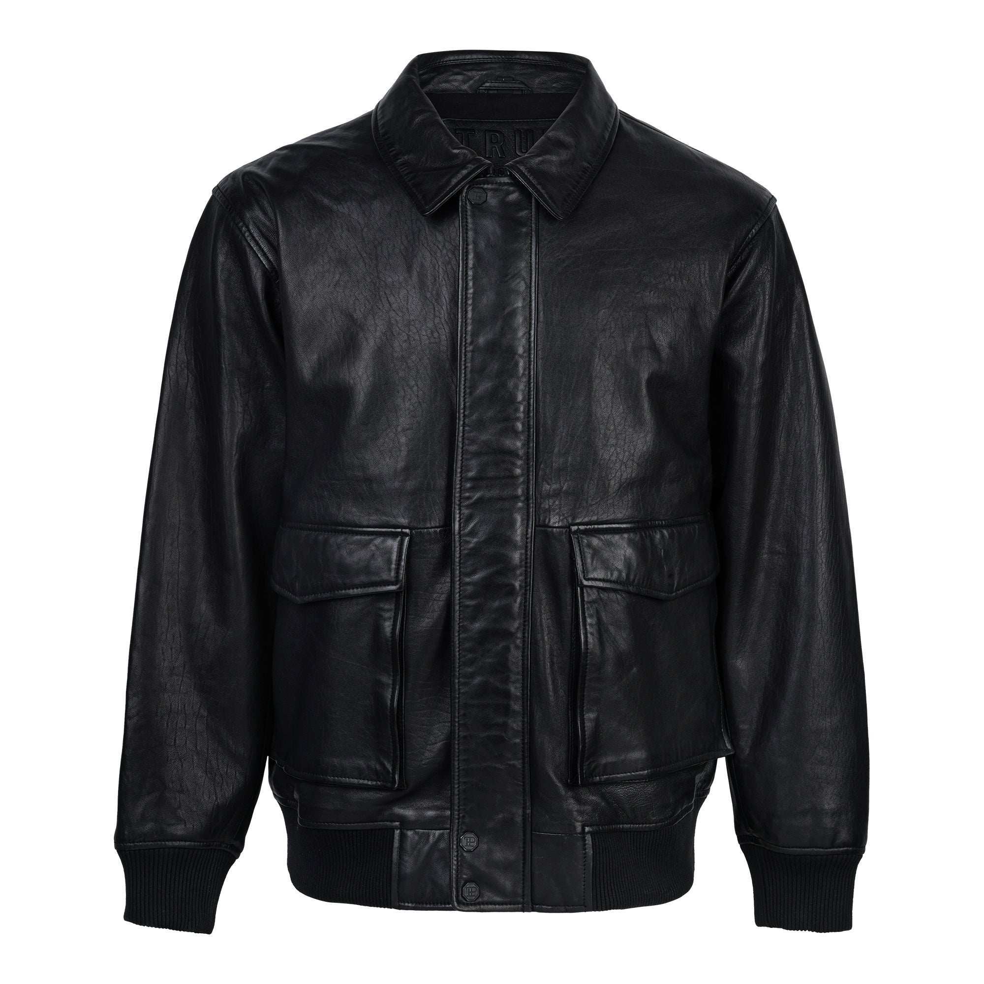 Die Ryder Oversize-Lederjacke von trueprodigy, gefertigt aus hochwertigem Schafsleder, verfügt über einen Stehkragen, 3D-Silikonlogo, Retro-Details, Frontreißverschluss und Druckknopfverschluss, zwei große Pattentaschen sowie gerippte Bündchen und Saum. Dargestellt auf weißem Hintergrund.