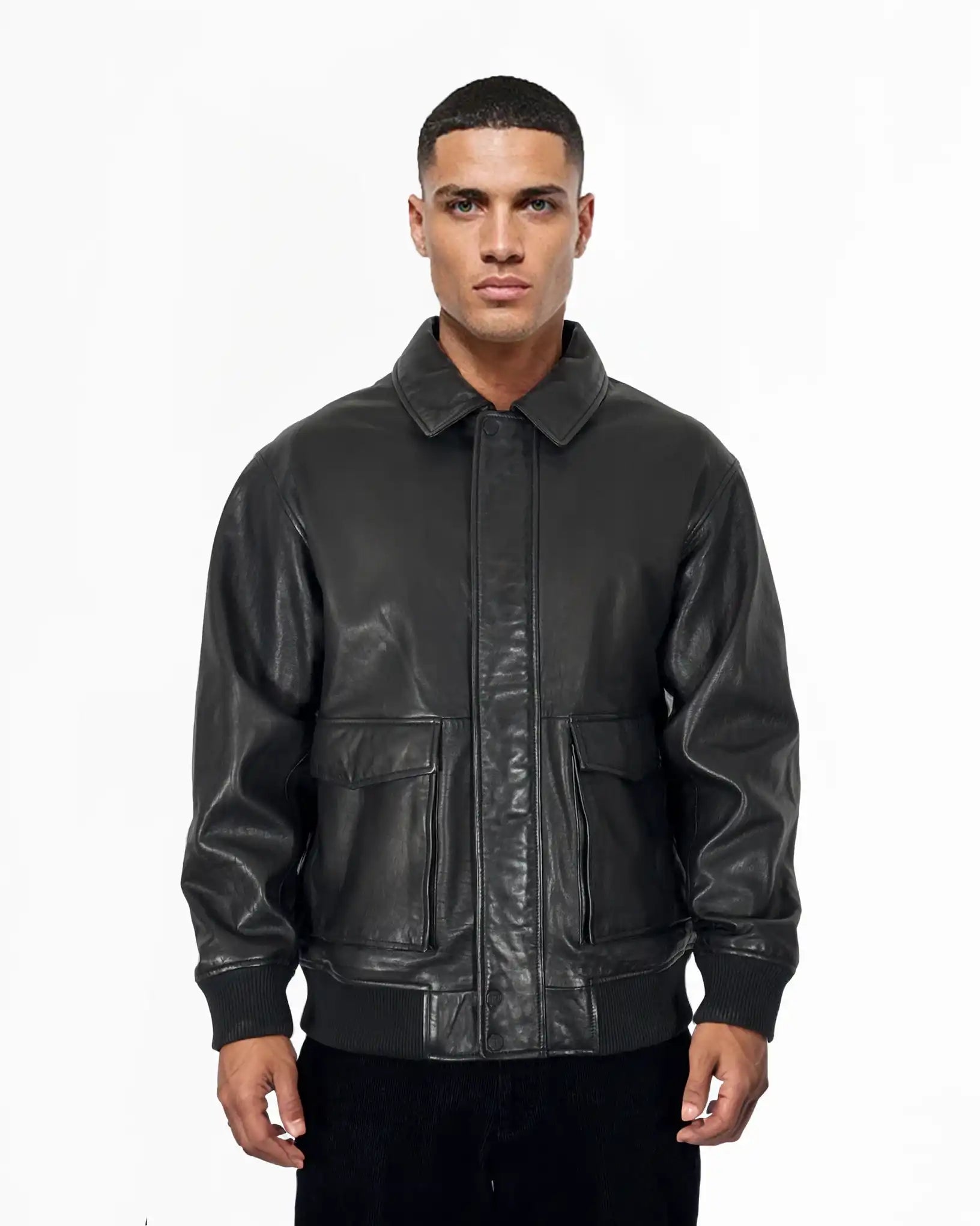 Ein Mann mit kurzen Haaren und neutralem Gesichtsausdruck blickt nach vorne, trägt die trueprodigy Ryder Oversize-Lederjacke mit Stehkragen, 3D-Silikonlogo & Retro-Details und steht vor einem schlichten weißen Hintergrund.