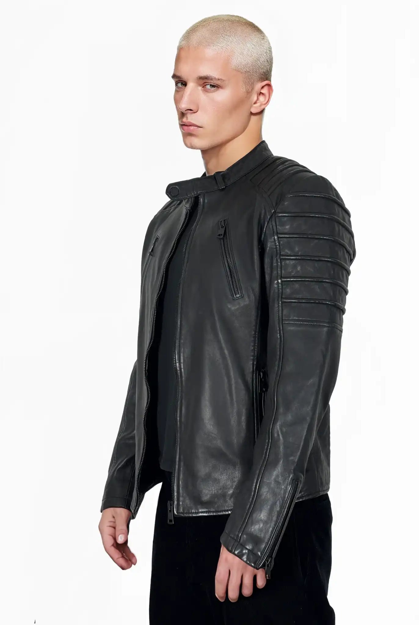 Eine Person mit kurzen, gebleichten blonden Haaren trägt die trueprodigy Dash Slim-Fit-Lederjacke mit Stehkragen & Zipper-Details, stehend vor einem schlichten weißen Hintergrund.