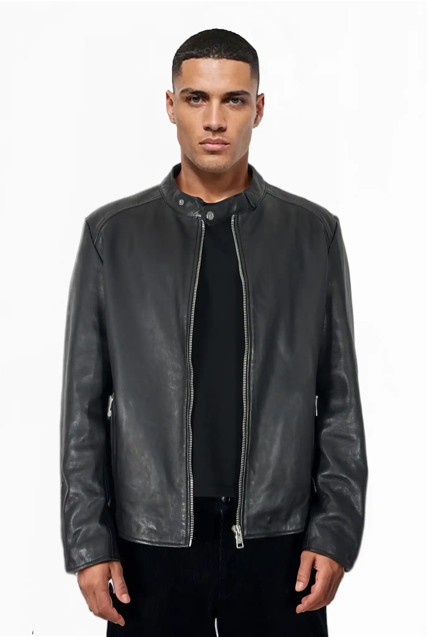 Ein Mann schaut nach vorne in einer trueprodigy Jonas Slim-Fit-Lederjacke aus schwarzem Schafsleder mit sichtbarem 3D-Rückenlogo, geschlossen über schwarzem Shirt und Hose. Die Jacke hat einen kleinen Kragen mit Druckknopf vor weißem Hintergrund.