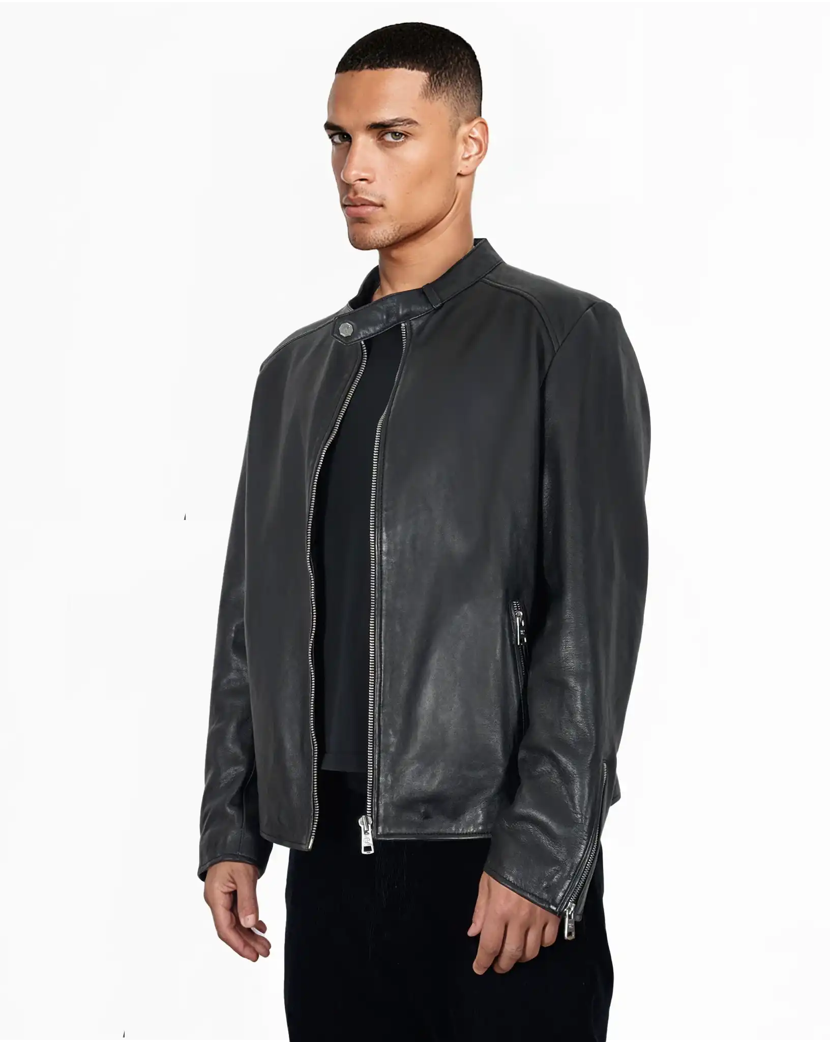 Ein Mann mit kurzen Haaren trägt die trueprodigy Jonas Slim-Fit-Lederjacke mit sichtbarem 3D-Rückenlogo über einem schwarzen Hemd und einer dunklen Hose, steht vor einem schlichten weißen Hintergrund und schaut leicht zur Seite.