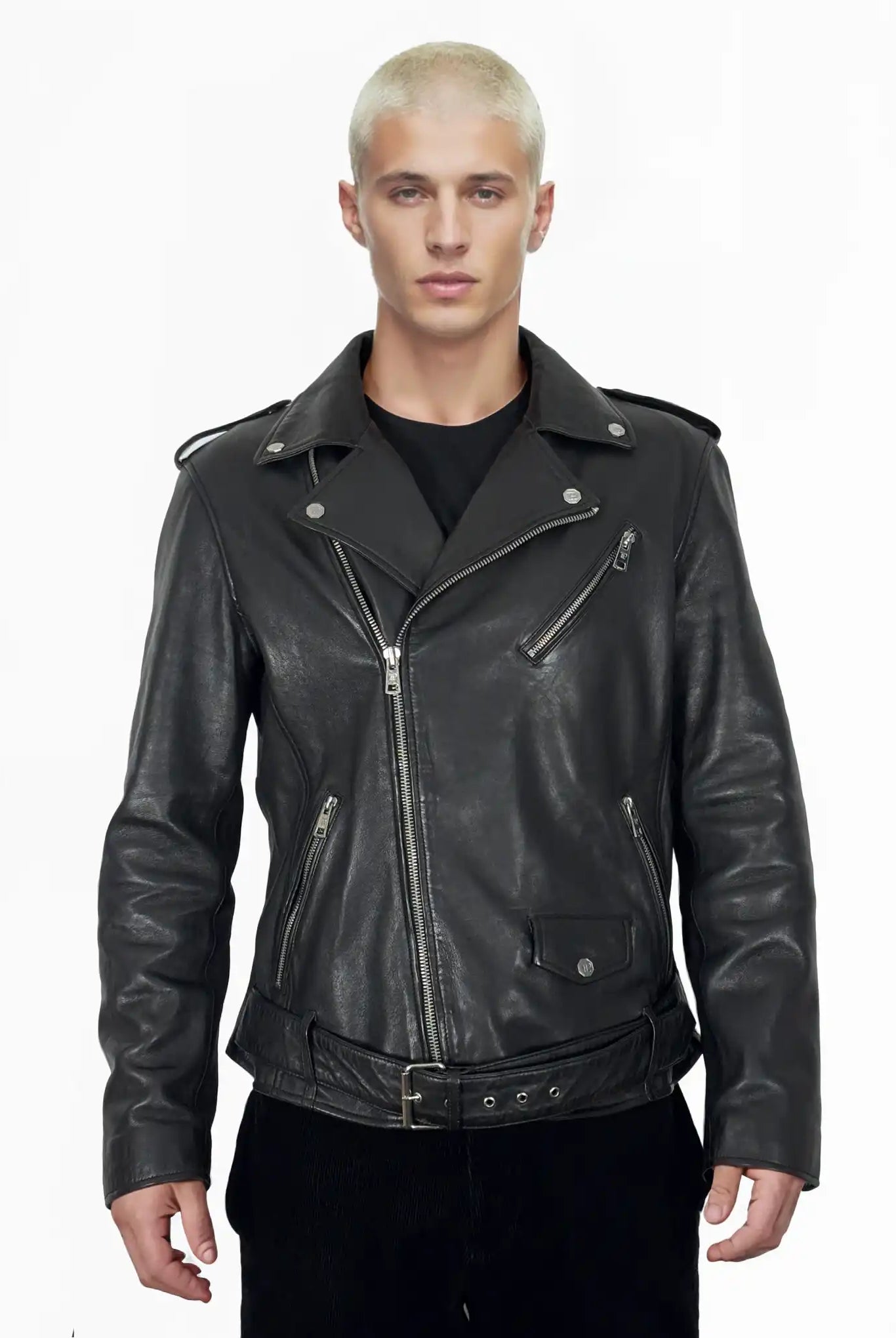 Eine Person mit kurzen, gebleichten blonden Haaren trägt die trueprodigy Easton Leder-Bikerjacke mit asymmetrischem Zipper & 3D-Logo unter dem Kragen über einem schwarzen Hemd, stehend vor einem schlichten weißen Hintergrund.