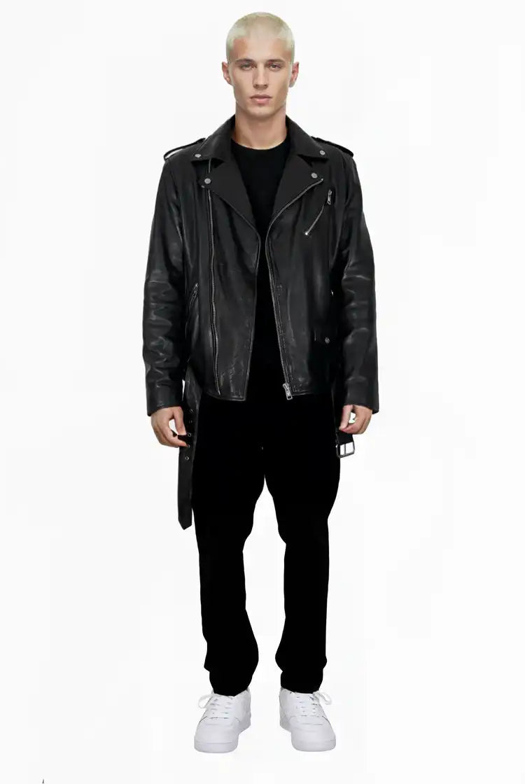Eine Person mit kurzen blonden Haaren sieht nach vorne und trägt eine trueprodigy Easton Leder-Bikerjacke mit asymmetrischem Reißverschluss und 3D-Logo unter dem Kragen, ein schwarzes Hemd, eine schwarze Hose und weiße Turnschuhe vor einem schlichten weißen Hintergrund.