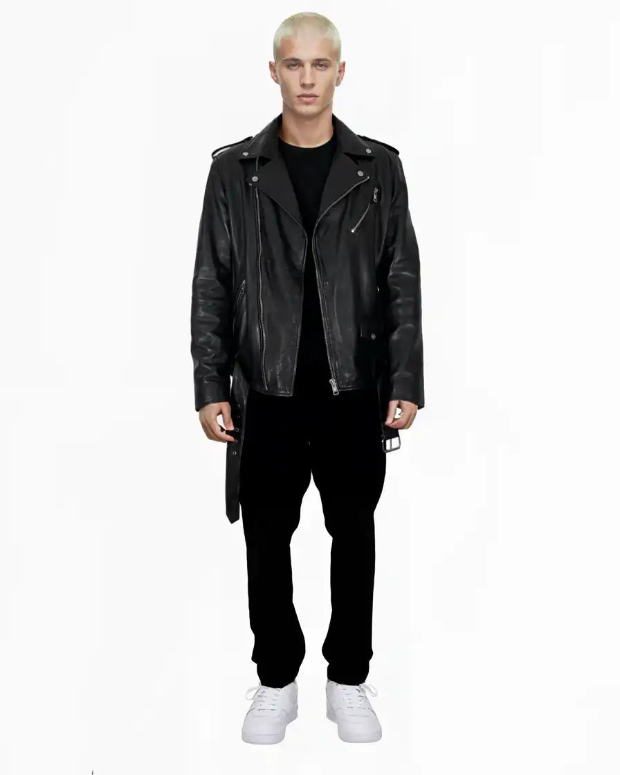 Eine Person mit kurzen blonden Haaren sieht nach vorne und trägt eine trueprodigy Easton Leder-Bikerjacke mit asymmetrischem Reißverschluss und 3D-Logo unter dem Kragen, ein schwarzes Hemd, eine schwarze Hose und weiße Turnschuhe vor einem schlichten weißen Hintergrund.