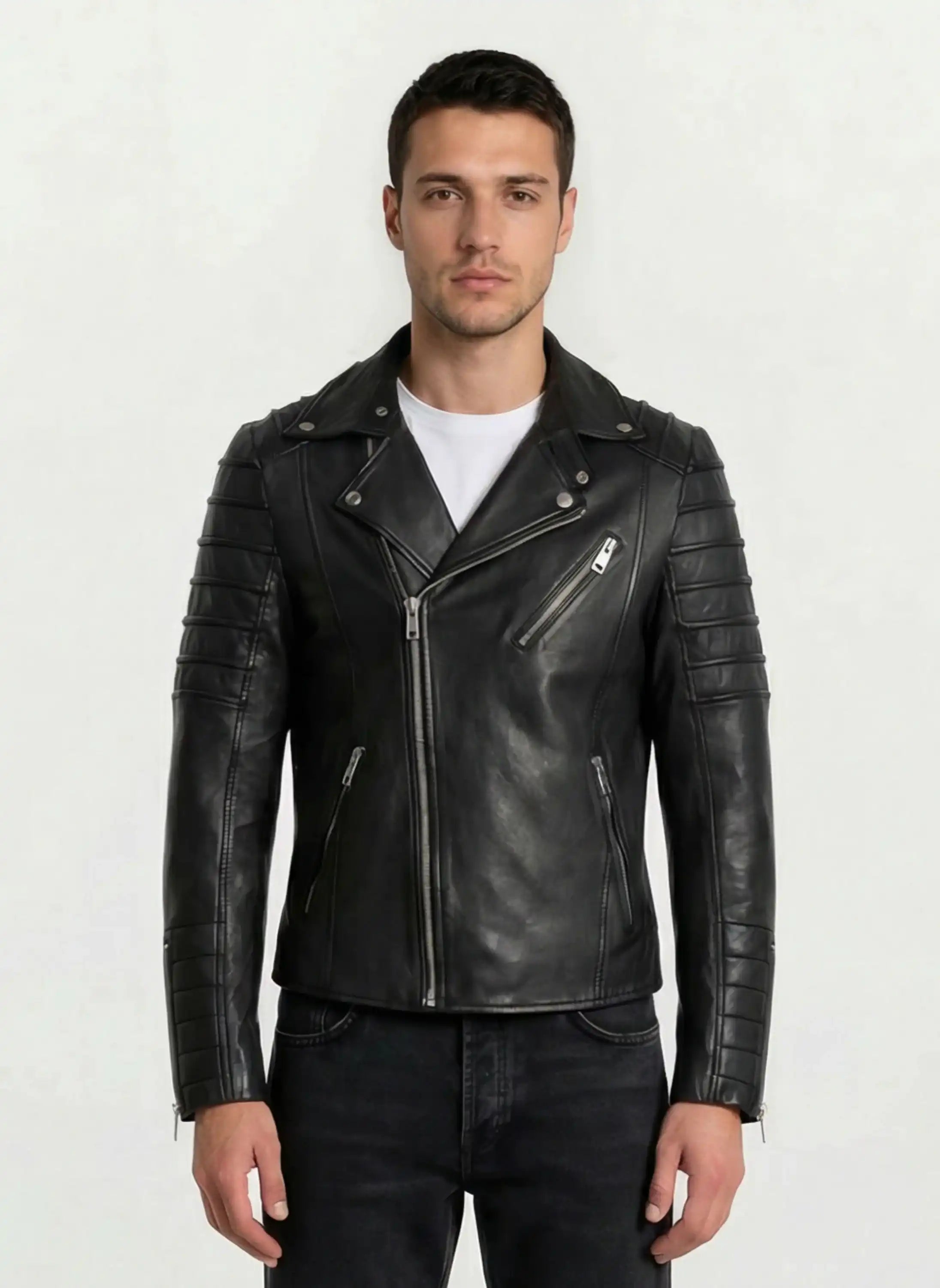 Ein Mann steht mit dem Gesicht nach vorne und trägt eine Trueprodigy Lederjacke mit Paspelierung und diversen Reißverschlüssen über einem weißen T-Shirt und schwarzen Jeans vor einem schlichten hellen Hintergrund.