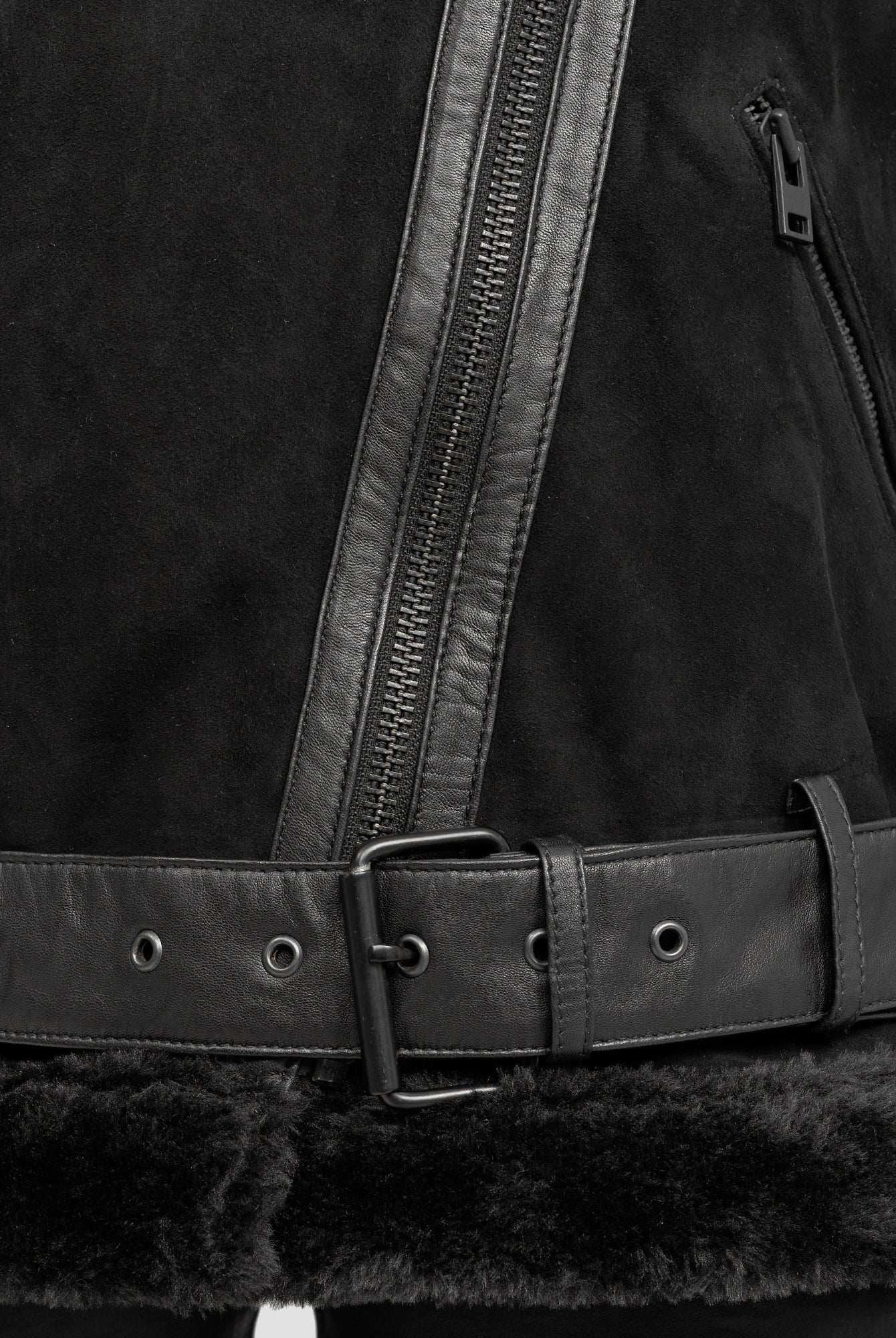 Nahaufnahme der Aloy Wilderlederjacke mit Gürtel von trueprodigy in Schwarz mit asymmetrischem Reißverschluss, Ledergürtel mit Metallschnalle und weichem Kunstpelzbesatz - ideal, um Ihren Stil zu unterstreichen.