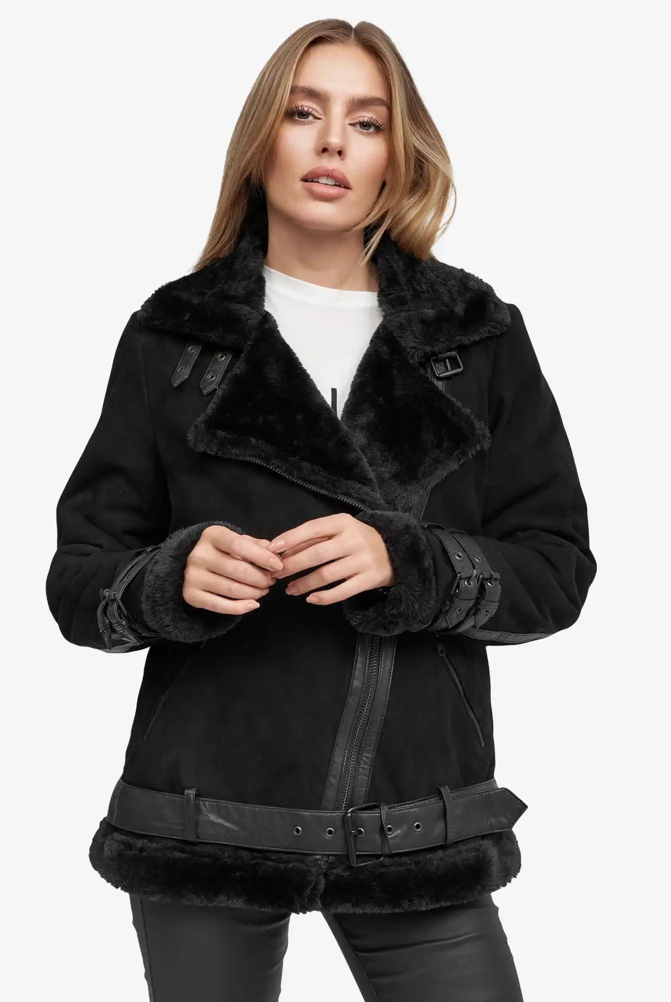 Eine Person steht mit dem Gesicht nach vorne und trägt eine schwarze Trueprodigy Aloy Wilderlederjacke mit Gürtel mit breitem Revers und silbernen Schnallen über einem weißen Hemd und einer schwarzen Hose vor einem schlichten weißen Hintergrund.