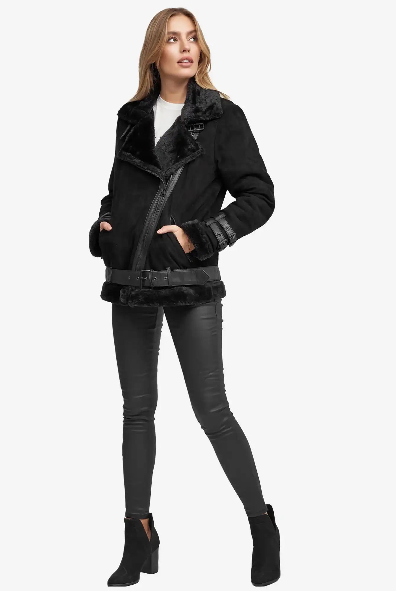 Eine Frau trägt eine schwarze Trueprodigy Aloy Wilderlederjacke mit Gürtel, eine schwarze Skinny-Hose, ein weißes Oberteil und schwarze Ankle Boots vor einem schlichten weißen Hintergrund.
