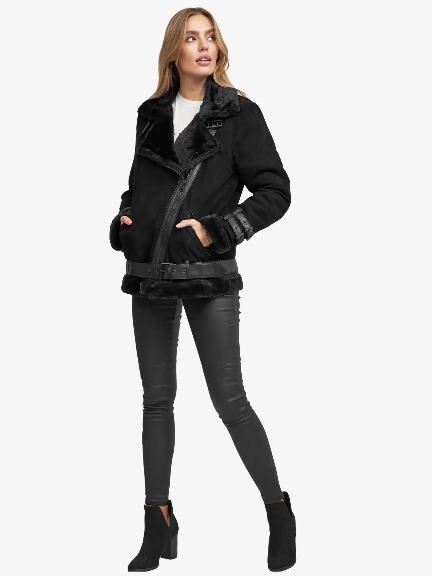 Eine Frau trägt eine schwarze Trueprodigy Aloy Wilderlederjacke mit Gürtel, eine schwarze Skinny-Hose, ein weißes Oberteil und schwarze Ankle Boots vor einem schlichten weißen Hintergrund.