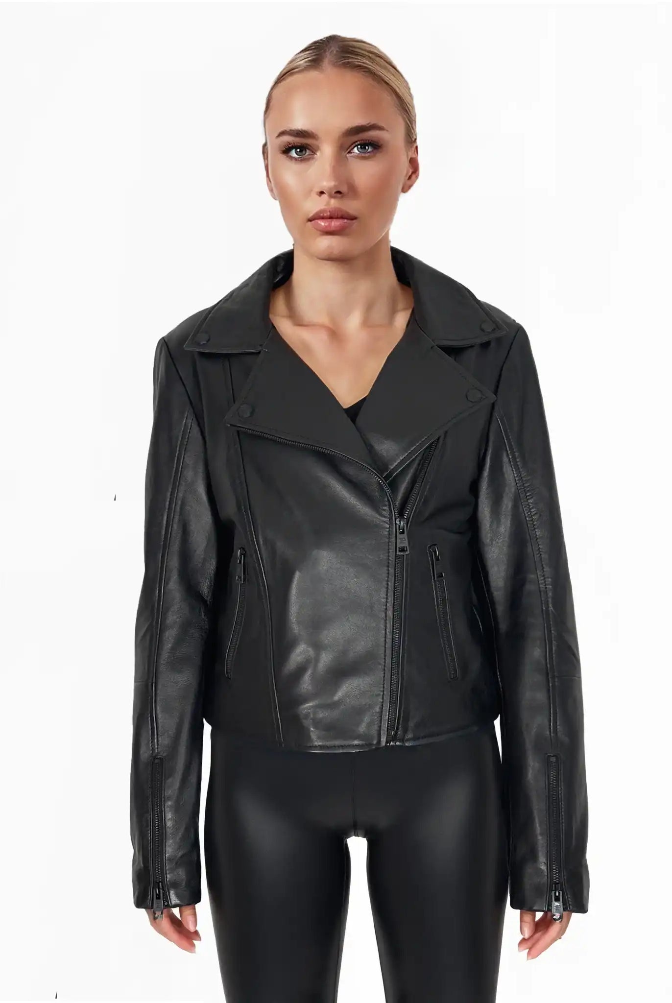 Eine Person steht mit dem Gesicht nach vorne vor einem schlichten weißen Hintergrund und trägt die trueprodigy Stella taillierte Lederjacke mit schwarzem Reißverschluss & Ärmelzipper, zusammen mit einer schwarzen Hose.