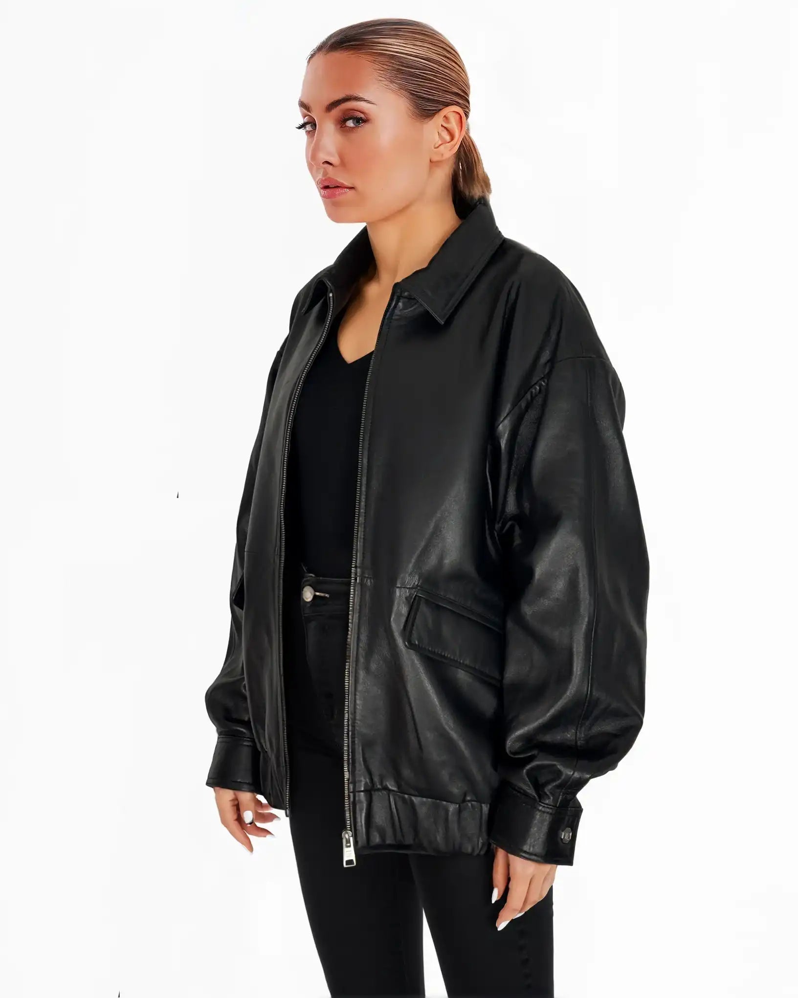 Eine hellhäutige Person mit zurückgekämmten Haaren trägt die trueprodigy Nova Oversize-Lederjacke mit Gummizugsaum & Lederdetails über einem schwarzen Oberteil und einer Hose vor einem schlichten weißen Hintergrund.