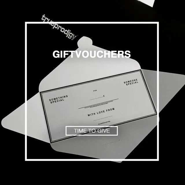 Ein Schwarzweißbild zeigt einen Umschlag mit einem TRUEPRODIGY-Geschenkgutschein darin. Der Gutschein hat Abschnitte mit den Beschriftungen „Für“, „Von“ und „Wert“. Er enthält die Sätze „Jemand Besonderes“ und „Zeit zum Schenken“ sowie das TRUEPRODIGY-Branding.