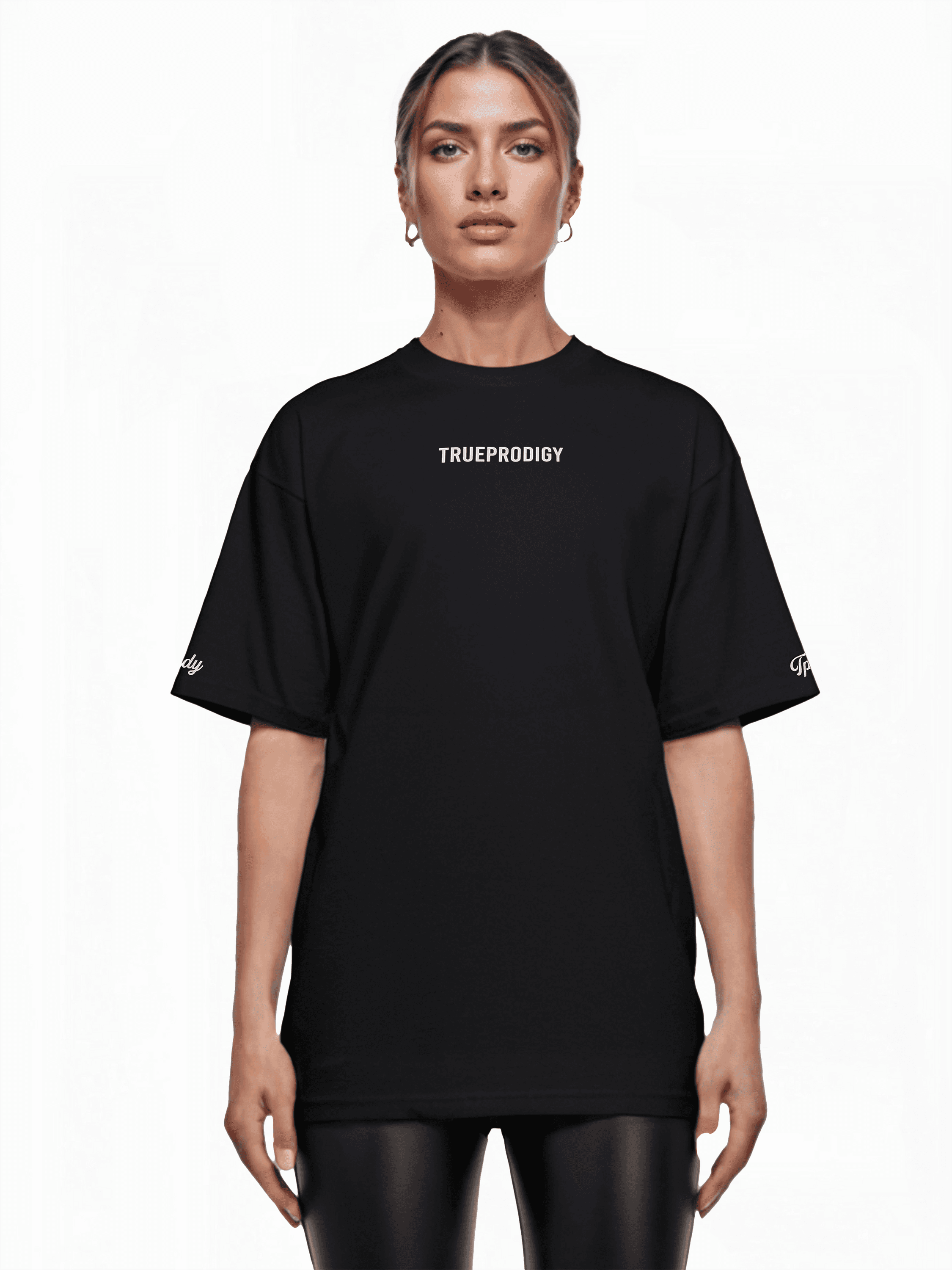Vor weißem Hintergrund trägt eine Person ein übergroßes Unisex-T-Shirt mit dem auffälligen Aufdruck „trueprodigy“ auf der Vorderseite. Ihre hellen Haare sind hochgesteckt, und eine elegante schwarze Hose rundet den Look ab. (Produkt: Kai F von trueprodigy).