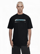 Eine Person mit kurzen blonden Haaren trägt ein übergroßes schwarzes Trueprodigy-T-Shirt „Ravi“, auf dessen Brust der Markenname in kräftigem Blau und Weiß auf einem schlichten weißen Hintergrund hervorsticht.