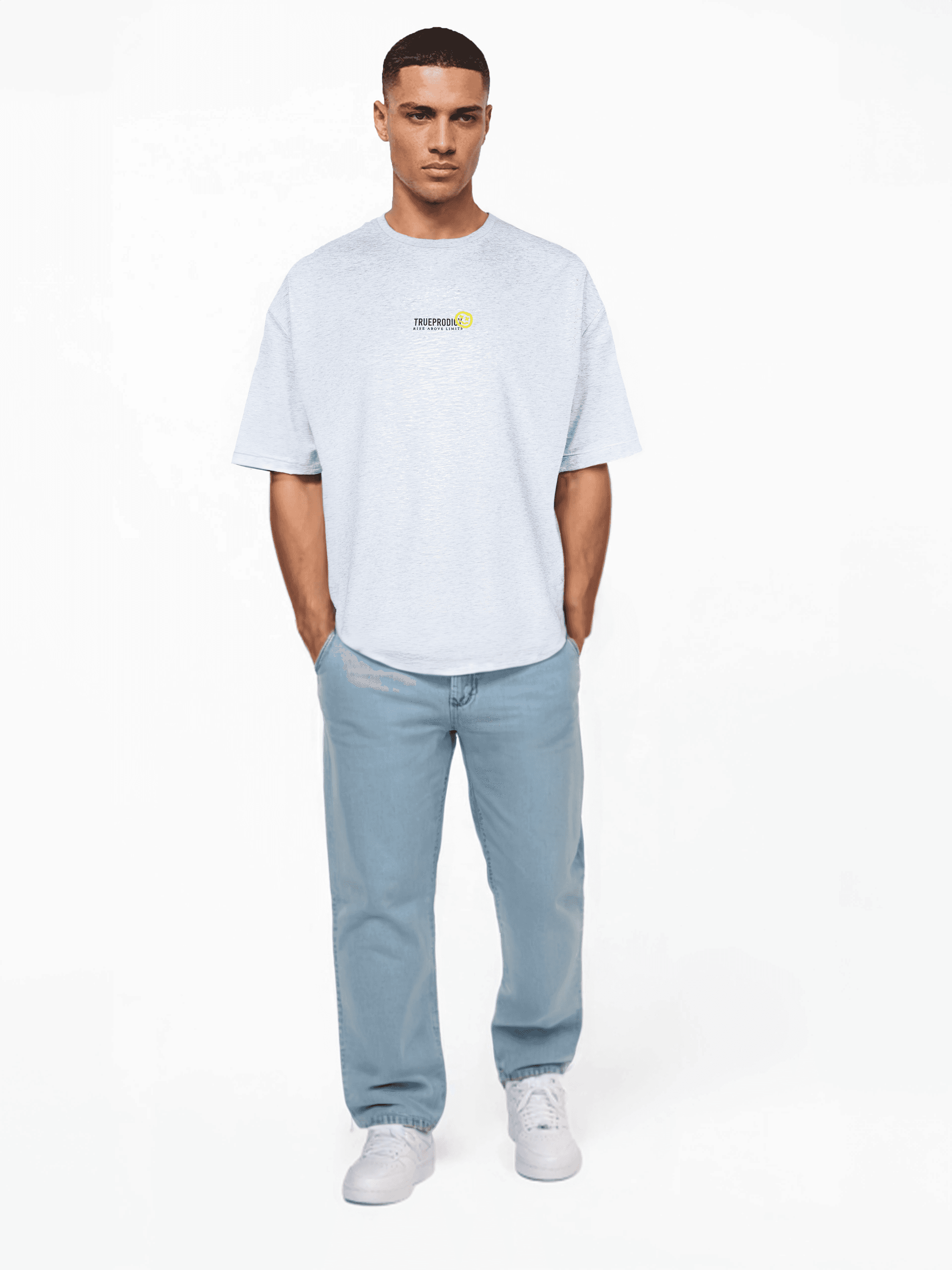 Vor einem schlichten weißen Hintergrund trägt jemand ein übergroßes Juniper-T-Shirt von trueprodigy aus weichem Jersey mit kleiner Grafik. Zusammen mit hellblauen Jeans und weißen Sneakers strahlen sie mühelosen Stil aus. Ihre kurzen dunklen Haare rahmen ihre entspannte Pose mit den Händen in den Taschen ein.