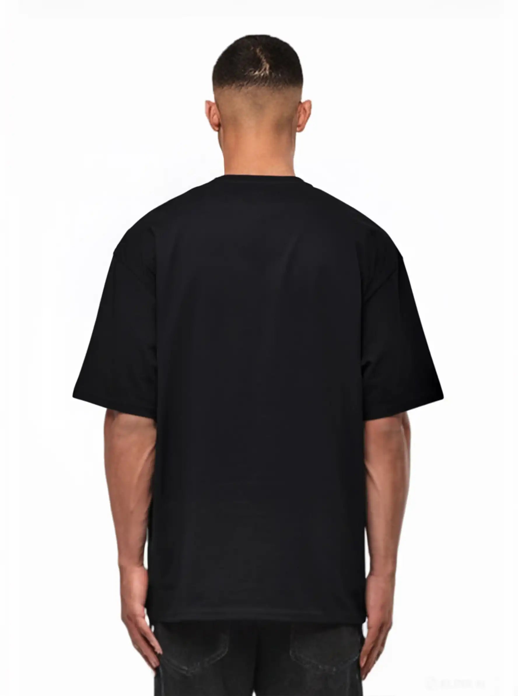 Eine Person steht mit dem Rücken zur Kamera, trägt ein trueprodigy Yuki Oversize-T-Shirt mit Adlergrafik & TPDY-Schriftzug und dunkle Jeans vor einem weißen Hintergrund.