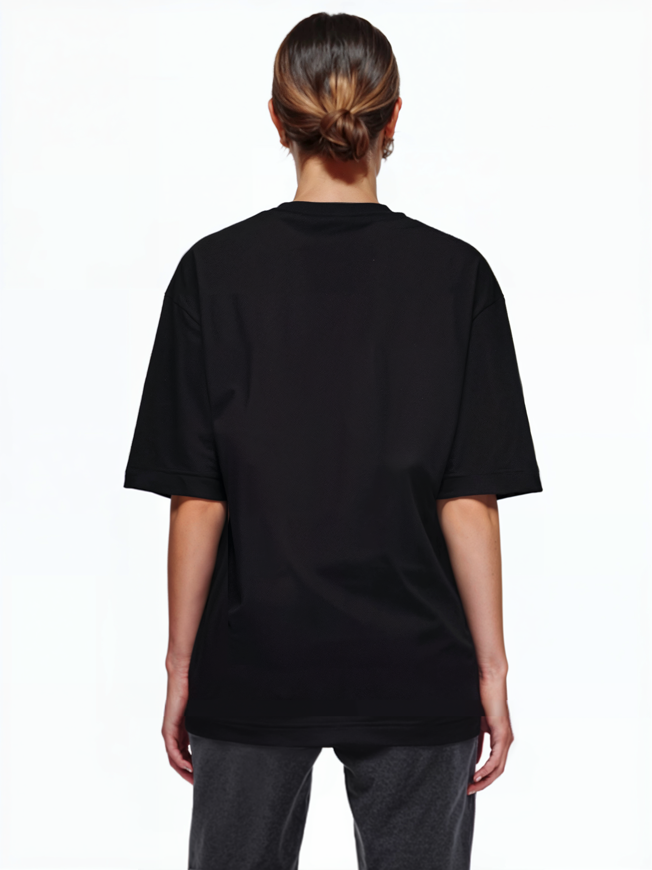 Eine Person mit braunen Haaren in einem tiefen Dutt ist von hinten zu sehen. Sie trägt ein trueprodigy Oversize-T-Shirt mit Adlergrafik & TRUEPRODIGY-Schriftzug und eine dunkle Hose und steht vor einem schlichten weißen Hintergrund.