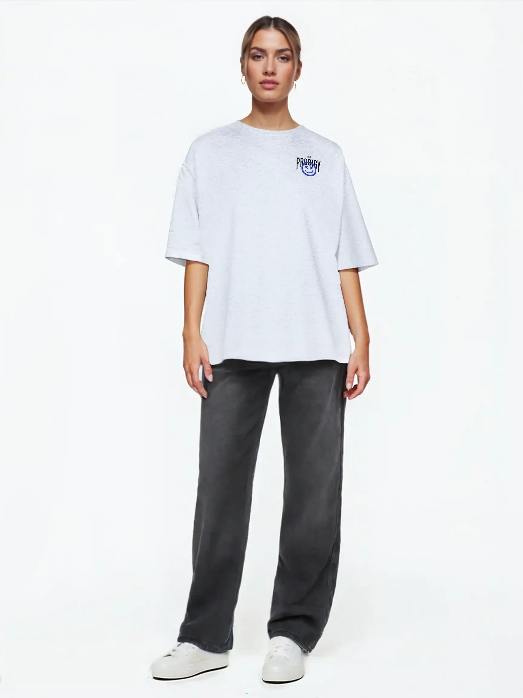 Eine Person steht vor einem weißen Hintergrund, trägt das trueprodigy Hajin F Oversize-T-Shirt mit Spray-Smiley & Happy-Mind-Print, dunkelgraue Jeans und weiße Turnschuhe, blickt nach vorne und hat einen neutralen Blick.