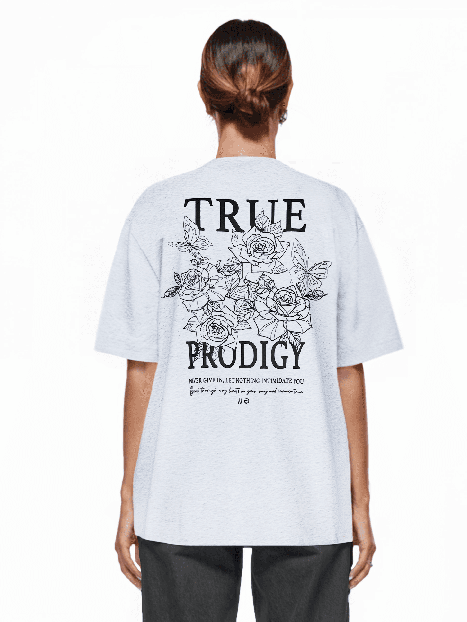 Eine Person mit braunem Haar trägt ein übergroßes hellgraues Unisex-T-Shirt „Alex F“ von trueprodigy mit dem Schriftzug „TRUE PRODIGY“ und einer Rosengrafik auf der Rückseite. Darunter befindet sich ein kleinerer Text. Der Look wird durch eine dunkle Hose aus bequemem Jerseystoff abgerundet.