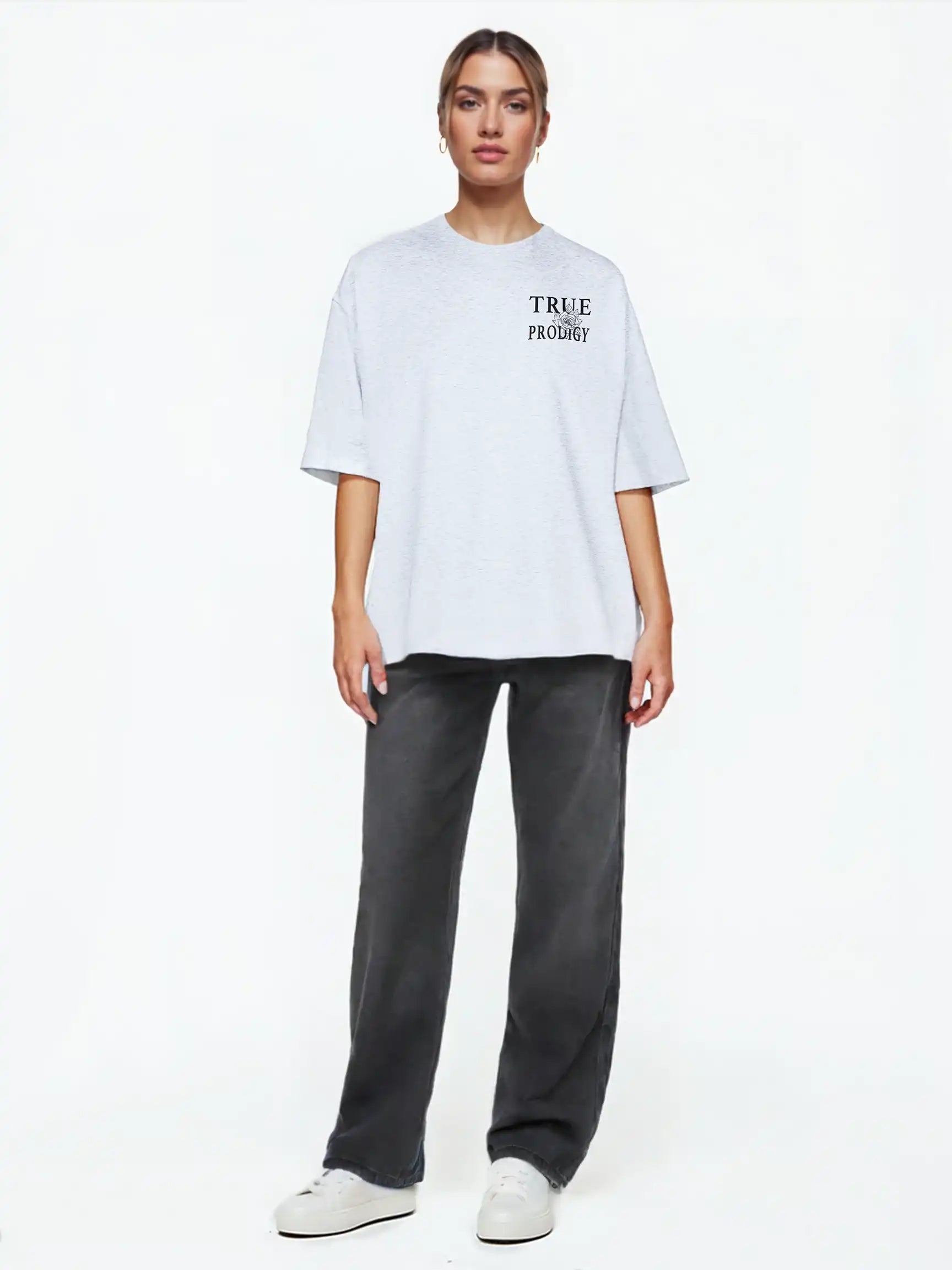 Eine Person steht mit dem Gesicht nach vorne und trägt ein hellgraues "Alex F Oversize-T-Shirt mit Spray-Smiley & trueprodigy-Schriftzug vorne & hinten" von trueprodigy, gepaart mit einer dunkelgrauen Hose und weißen Turnschuhen, vor einem schlichten weißen Hintergrund.